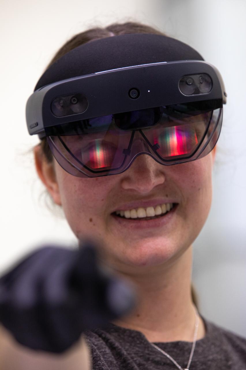 Mary Lakaszcyck, a technician with ASRC Federal Data Solutions, wears a pair of augmented reality (AR) goggles inside the high bay of the Neil Armstrong Operations and Checkout Building at NASA’s Kennedy Space Center in Florida on Jan. 16, 2020. Orion manufacturer Lockheed Martin provided the goggles to technicians to help place tapes where components will be installed on the Orion crew module adapter for NASA’s Artemis II mission, the first crewed mission aboard the spacecraft. Using the AR goggles saves significant labor and time to complete tasks. Manufactured by Microsoft, the goggles, called HoloLens2, are the second version used by Lockheed.