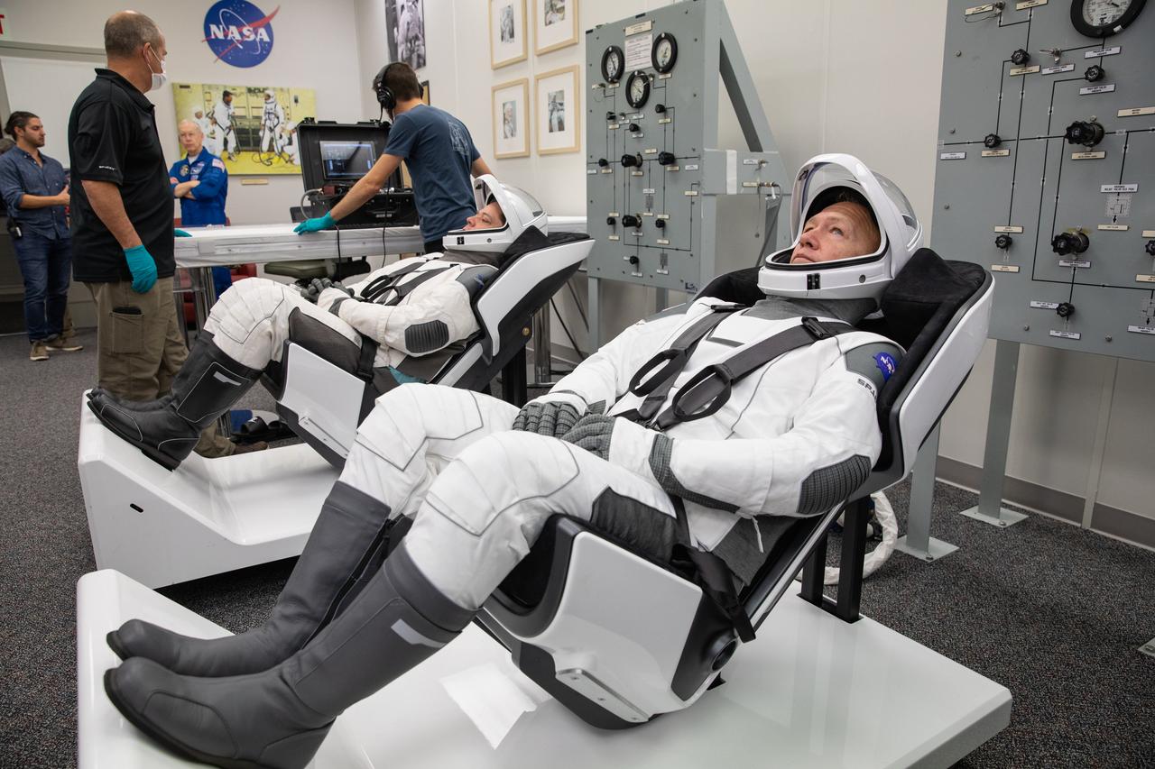 NASA astronauts Doug Hurley, foreground, and Bob Behnken don SpaceX spacesuits in the Astronaut Crew Quarters at Kennedy Space Center in Florida on Jan. 17, 2020, during a dress rehearsal ahead of the company’s uncrewed In-Flight Abort Test. A SpaceX Falcon 9 rocket and Crew Dragon spacecraft will lift off from Launch Complex 39A on the flight test, which will demonstrate the spacecraft’s escape capabilities in preparation for crewed flights to the International Space Station as part of the agency’s Commercial Crew Program. Hurley and Behnken are slated to fly on the company’s first crewed mission, Demo-2.