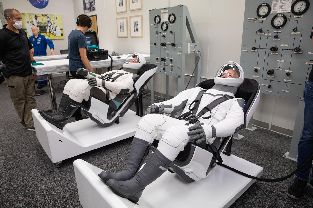 NASA astronauts Doug Hurley, foreground, and Bob Behnken don SpaceX spacesuits in the Astronaut Crew Quarters at Kennedy Space Center in Florida on Jan. 17, 2020, during a dress rehearsal ahead of the company’s uncrewed In-Flight Abort Test. A SpaceX Falcon 9 rocket and Crew Dragon spacecraft will lift off from Launch Complex 39A on the flight test, which will demonstrate the spacecraft’s escape capabilities in preparation for crewed flights to the International Space Station as part of the agency’s Commercial Crew Program. Hurley and Behnken are slated to fly on the company’s first crewed mission, Demo-2.