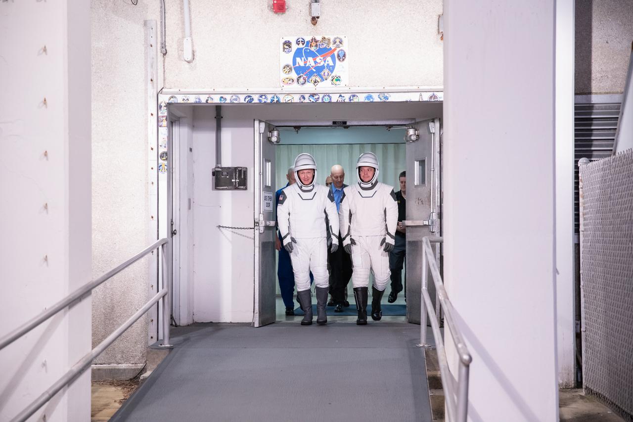 NASA astronauts Bob Behnken, left, and Doug Hurley, wearing SpaceX spacesuits, walk out of the Neil A. Armstrong Operations and Checkout Building at Kennedy Space Center in Florida on Jan. 17, 2020, during a dress rehearsal ahead of the SpaceX uncrewed In-Flight Abort Test. A SpaceX Falcon 9 rocket and Crew Dragon spacecraft will lift off from Launch Complex 39A on the flight test, which will demonstrate the spacecraft’s escape capabilities in preparation for crewed flights to the International Space Station as part of the agency’s Commercial Crew Program. Behnken and Hurley are slated to fly on the company’s first crewed mission, Demo-2.