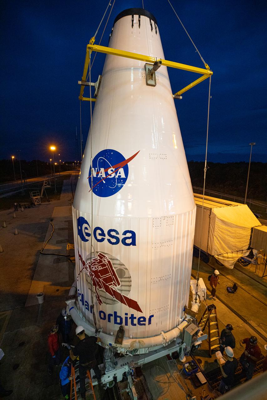 The United Launch Alliance Atlas V payload fairing, containing the Solar Orbiter spacecraft, is hoisted up by crane at the Vertical Integration Facility at Space Launch Complex 41 on Cape Canaveral Air Force Station in Florida on Jan. 31, 2020. The payload fairing will be mated to the Atlas V rocket. Solar Orbiter is an international cooperative mission between ESA (European Space Agency) and NASA. The mission aims to study the Sun, its outer atmosphere and solar wind. The spacecraft will provide the first images of the Sun’s poles. NASA’s Launch Services Program based at Kennedy is managing the launch. The spacecraft has been developed by Airbus Defence and Space. Solar Orbiter will launch in February 2020 aboard the Atlas V rocket. 