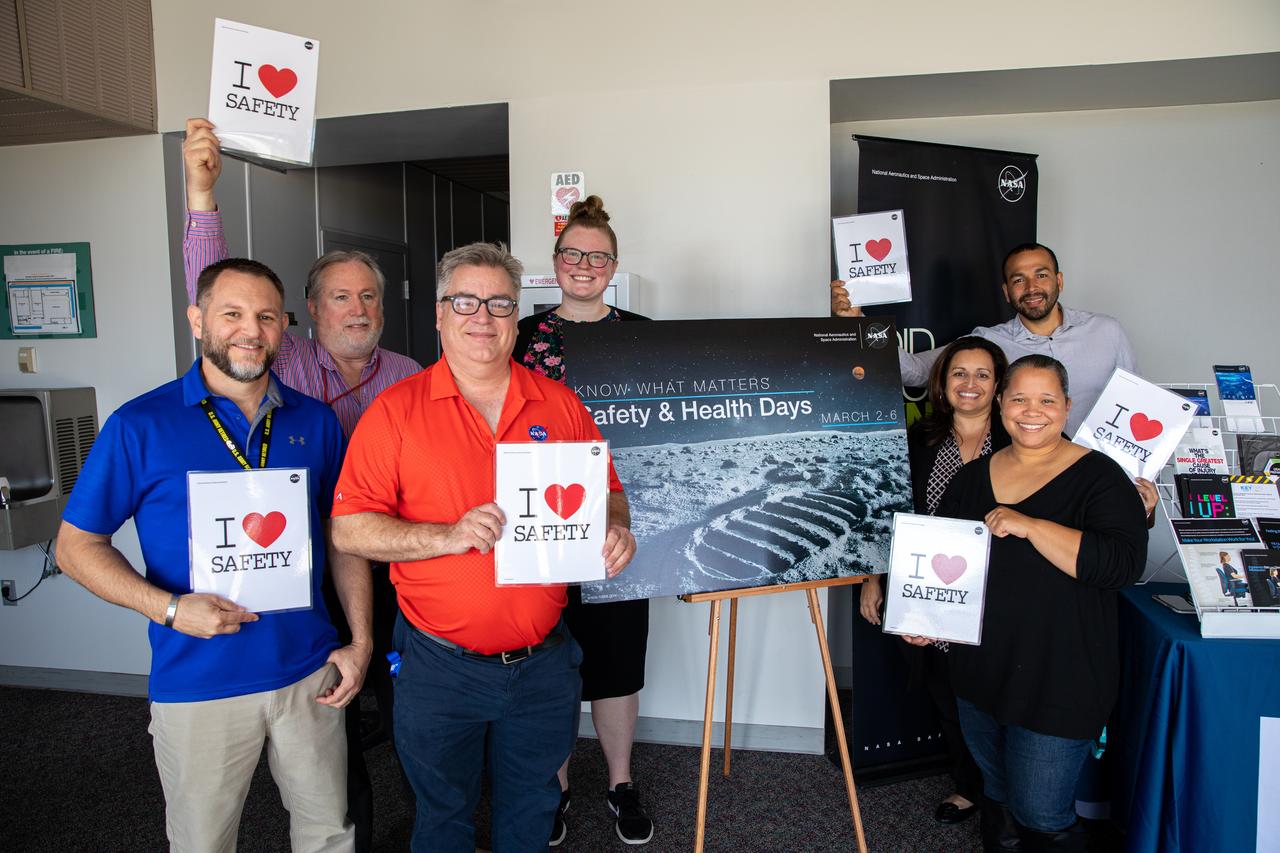 From left to right, Kennedy Space Center Safety and Mission Assurance (SMA) employees Sean Nichols, Tom Dwyer, Gary Hendricks, Larrin Moody, Michele Richtmeyer, Heidi Harden and Jeff Silva pose with SMA “I Love Safety” posters inside the Training Auditorium on March 2, 2020, during the center’s annual Safety and Health Days. Taking place March 2 through March 6, Safety and Health Days provides Kennedy employees with a variety of presentations to attend – all of which focus on how to maintain a safe and healthy workforce.