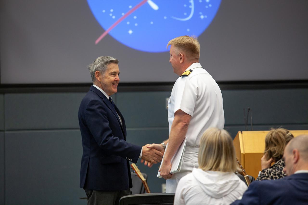 Kennedy Space Center Director Bob Cabana, left, shakes hands with Captain Ben Shupp, commanding officer, Naval Ordnance Test Unit, at the Florida spaceport on March 10, 2020. The United States Naval Academy Glee Club performed for Kennedy employees during a special celebration, which included Cabana discussing the deep historical ties between NASA and the U.S. Navy. The highly acclaimed Glee Club has achieved prominence as one of America’s premier choral ensembles, performing throughout the nation each year.