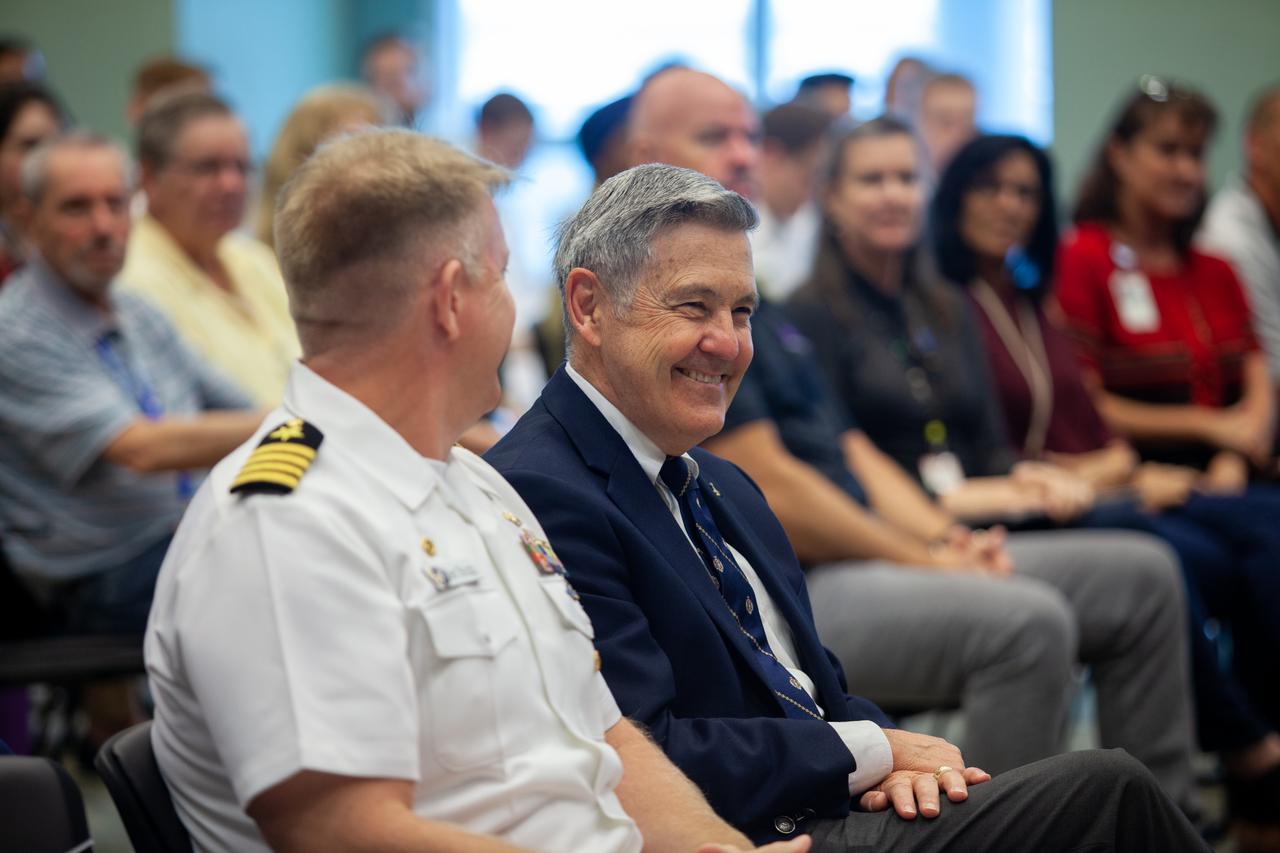 Kennedy Space Center Director Bob Cabana shares a laugh with Captain Ben Shupp, commanding officer, Naval Ordnance Test Unit, at the Florida spaceport on March 10, 2020. The United States Naval Academy Glee Club performed for Kennedy employees as part of a special celebration. Cabana also discussed the deep historical ties between NASA and the U.S. Navy. The highly acclaimed Glee Club has achieved prominence as one of America’s premier choral ensembles, performing throughout the nation each year.