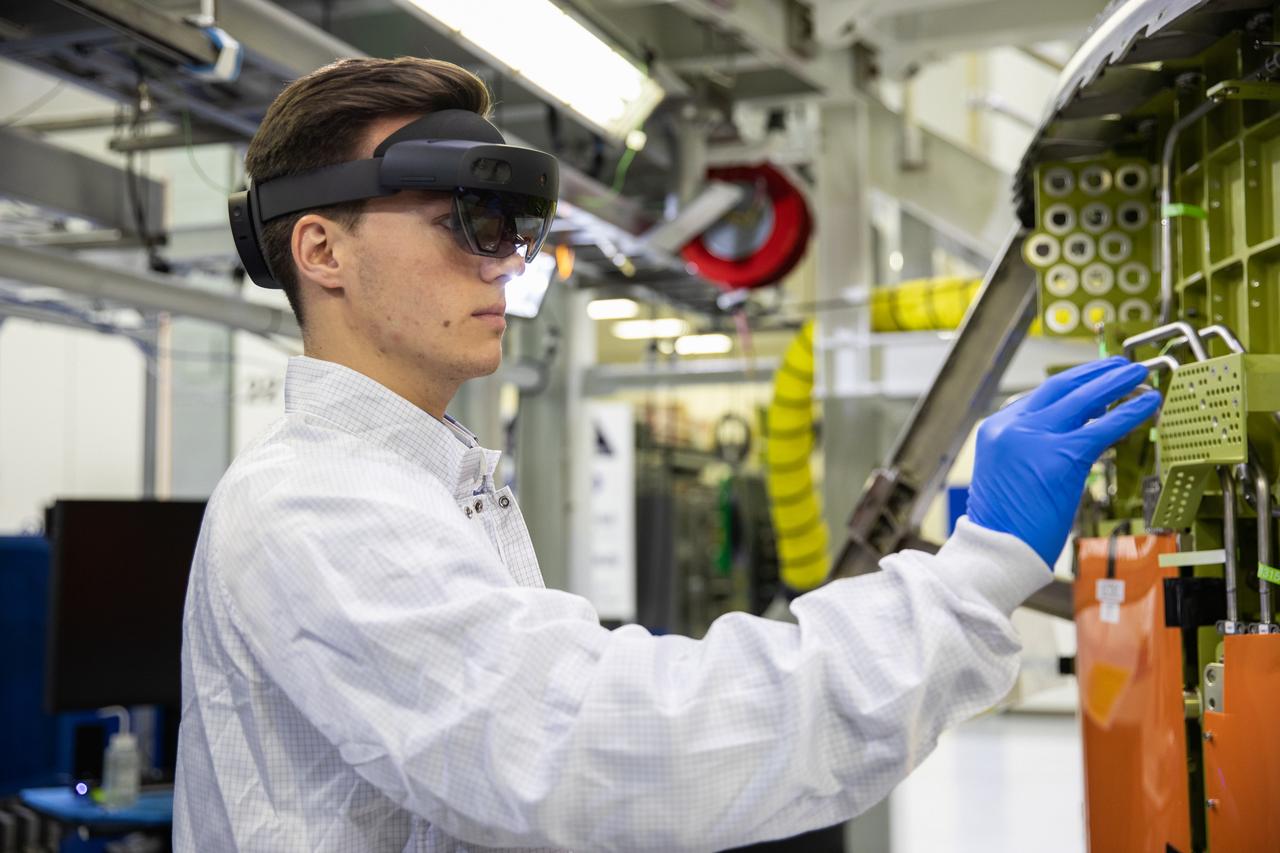 Michael Maxwell, with Lockheed Martin’s augmented reality team, wears a pair of augmented reality (AR) goggles to work on the crew module for NASA’s Artemis II mission inside the high bay of the Neil Armstrong Operations and Checkout Building at the agency’s Kennedy Space Center in Florida on March 18, 2020. Orion manufacturer Lockheed Martin provided the goggles to technicians to help place tapes where components will be installed on the crew module adapter for Artemis II, the first crewed mission aboard the spacecraft. Using the AR goggles saves significant labor and time to complete tasks. Manufactured by Microsoft, the goggles, called HoloLens2, are the second version used by Lockheed.