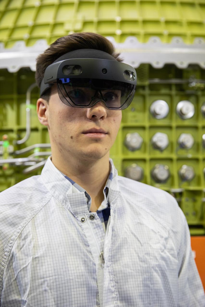 Michael Maxwell, with Lockheed Martin’s augmented reality team, wears a pair of augmented reality (AR) goggles to work on the crew module for NASA’s Artemis II mission inside the high bay of the Neil Armstrong Operations and Checkout Building at the agency’s Kennedy Space Center in Florida on March 18, 2020. Orion manufacturer Lockheed Martin provided the goggles to technicians to help place tapes where components will be installed on the crew module adapter for Artemis II, the first crewed mission aboard the spacecraft. Using the AR goggles saves significant labor and time to complete tasks. Manufactured by Microsoft, the goggles, called HoloLens2, are the second version used by Lockheed.