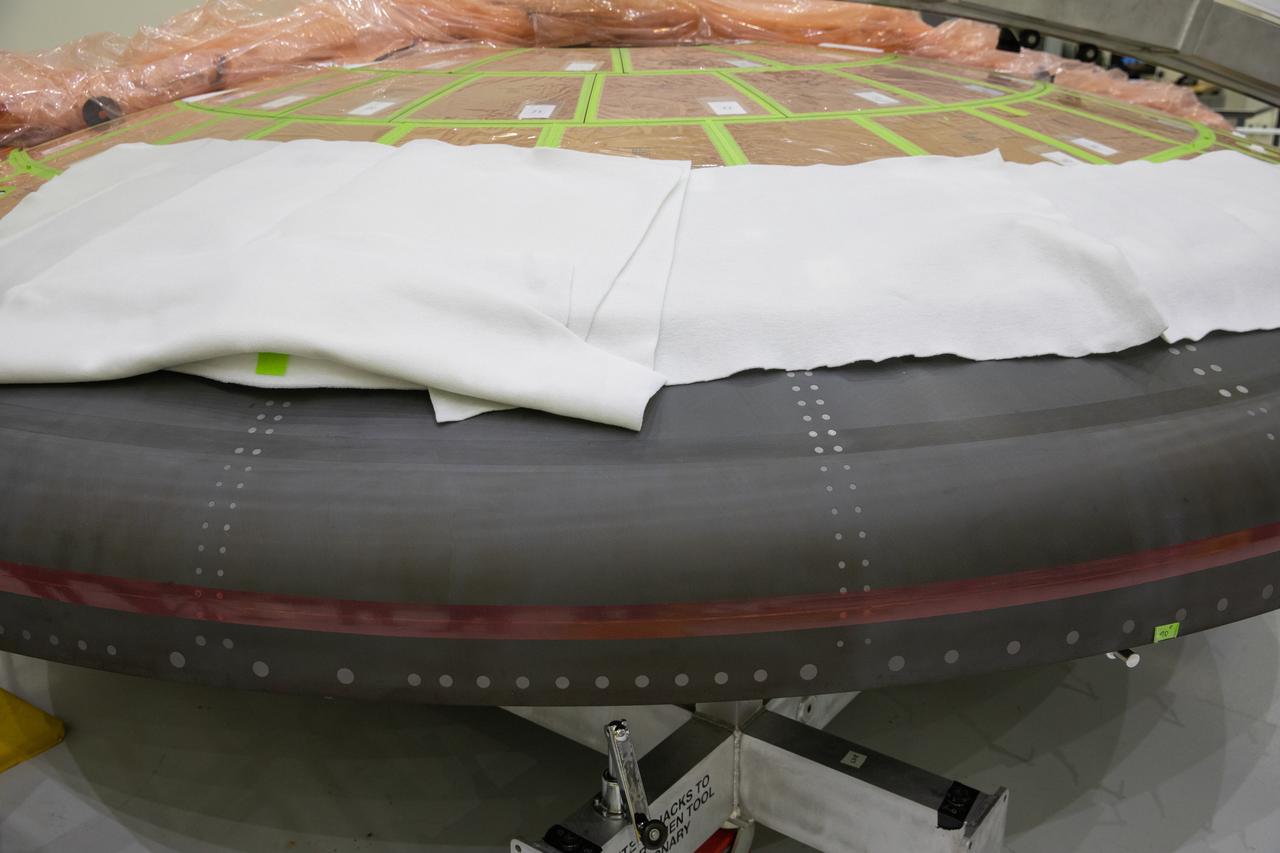 The heat shield for NASA’s Artemis II mission is in view inside the Neil Armstrong Operations and Checkout Building at the agency’s Kennedy Space Center in Florida on March 18, 2020. Using augmented reality (AR) goggles, technicians are completing the work on the heat shield. Orion manufacturer Lockheed Martin provided the goggles to technicians to help place tapes where components will be installed on the crew module, heat shield and other components for Artemis II, the first crewed mission aboard the spacecraft. Using the AR goggles saves significant labor and time to complete tasks. Manufactured by Microsoft, the goggles, called HoloLens2, are the second version used by Lockheed.