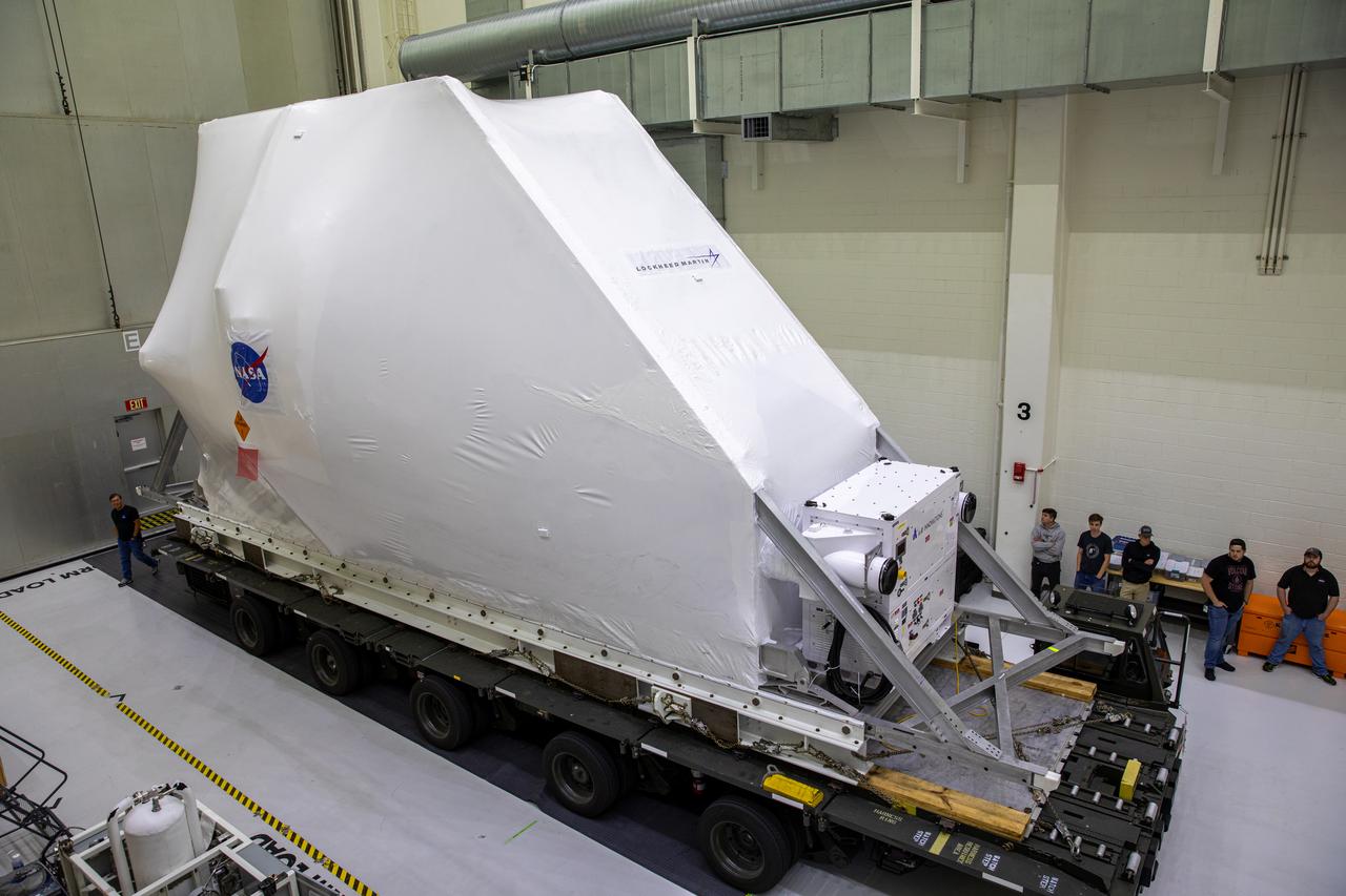 The Orion spacecraft, secured atop a transporter in its shipping container, arrives at the Neil Armstrong Operations and Checkout Building at NASA’s Kennedy Space Center in Florida on March 25, 2020, for final testing and assembly. The spacecraft was transported to Kennedy in NASA’s Super Guppy aircraft from the agency’s Plum Brook Station in Ohio, where it underwent two phase of environmental testing. Following these final preparations, Orion will be integrated with the Space Launch System rocket for the Artemis I launch – the first in a series of increasingly complex missions to the Moon that will ultimately lead to the exploration of Mars.