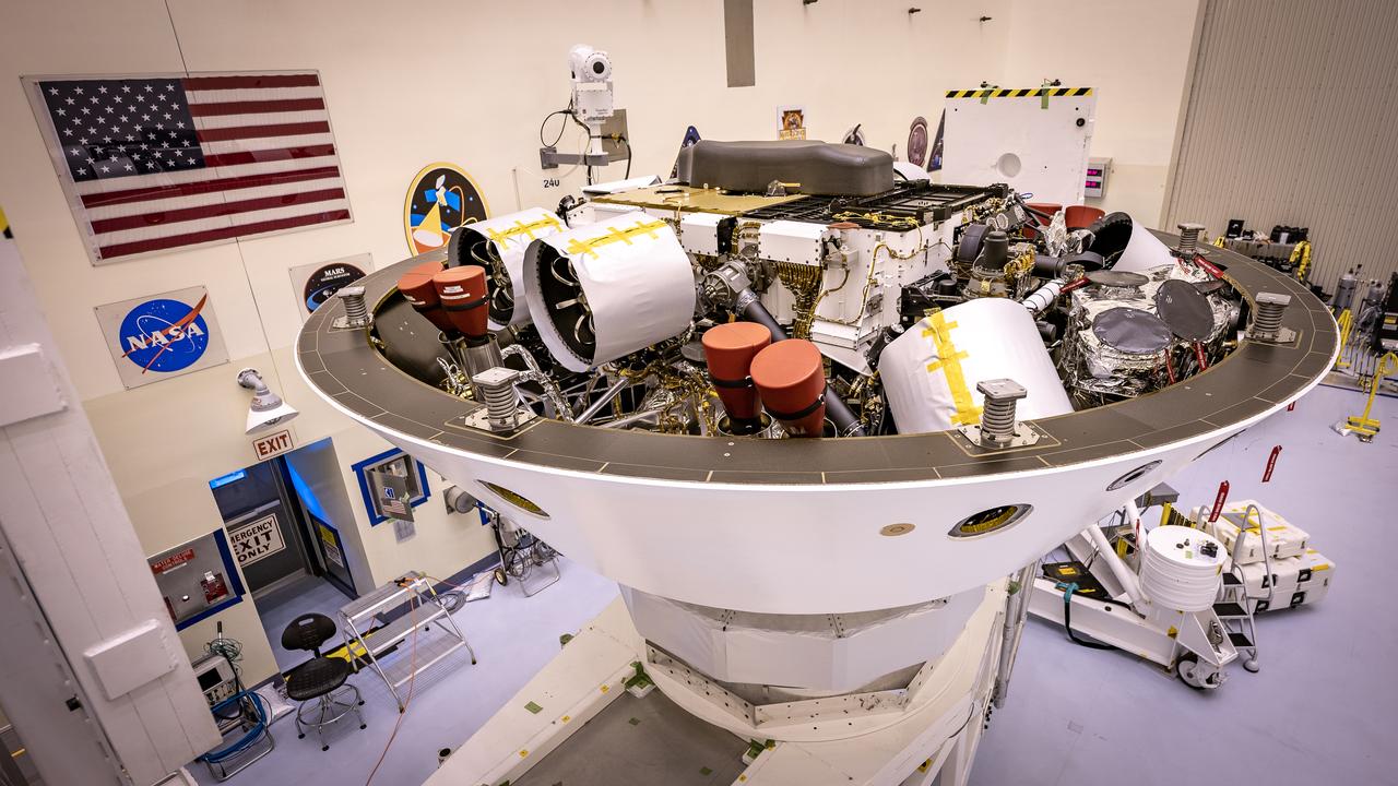 Inside the Payload Hazardous Servicing Facility at NASA’s Kennedy Space Center in Florida, the Mars Perseverance rover is rotated to prepare for the Backshell-Powered Descent Vehicle and Entry Vehicle assemblies to be attached on May 4, 2020. The cone-shaped backshell contains the parachute, and along with the mission’s heat shield, provides protection for the rover and descent stage during Martian atmospheric entry. The Mars Perseverance rover is scheduled to launch in mid-July atop a United Launch Alliance Atlas V 541 rocket from Pad 41 at nearby Cape Canaveral Air Force Station. The rover is part of NASA’s Mars Exploration Program, a long-term effort of robotic exploration of the Red Planet. The rover will search for habitable conditions in the ancient past and signs of past microbial life on Mars. The Launch Services Program at Kennedy is responsible for launch management.