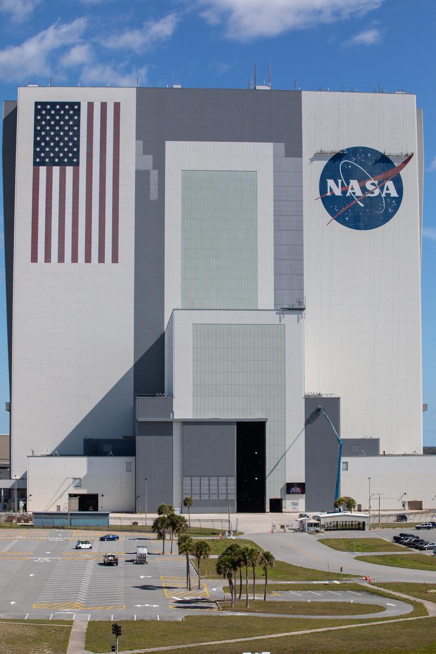 Painting of the NASA logo, also called the meatball, is underway on the 525-foot-tall Vehicle Assembly Building (VAB) at the agency’s Kennedy Space Center in Florida on May 8, 2020. HM2 and H.I.S. Painting of Titusville, Florida, are repainting the meatball and the American Flag on the iconic building. High Bay 3 inside the VAB has been upgraded with 10 new levels of work platforms that will surround and provide access for service and processing of NASA's Space Launch System (SLS) rocket and Orion spacecraft. Exploration Ground Systems is overseeing upgrades to the VAB to support the launch of the SLS and Orion for Artemis missions. Under the Artemis program, NASA will send the first woman and next man to the Moon.