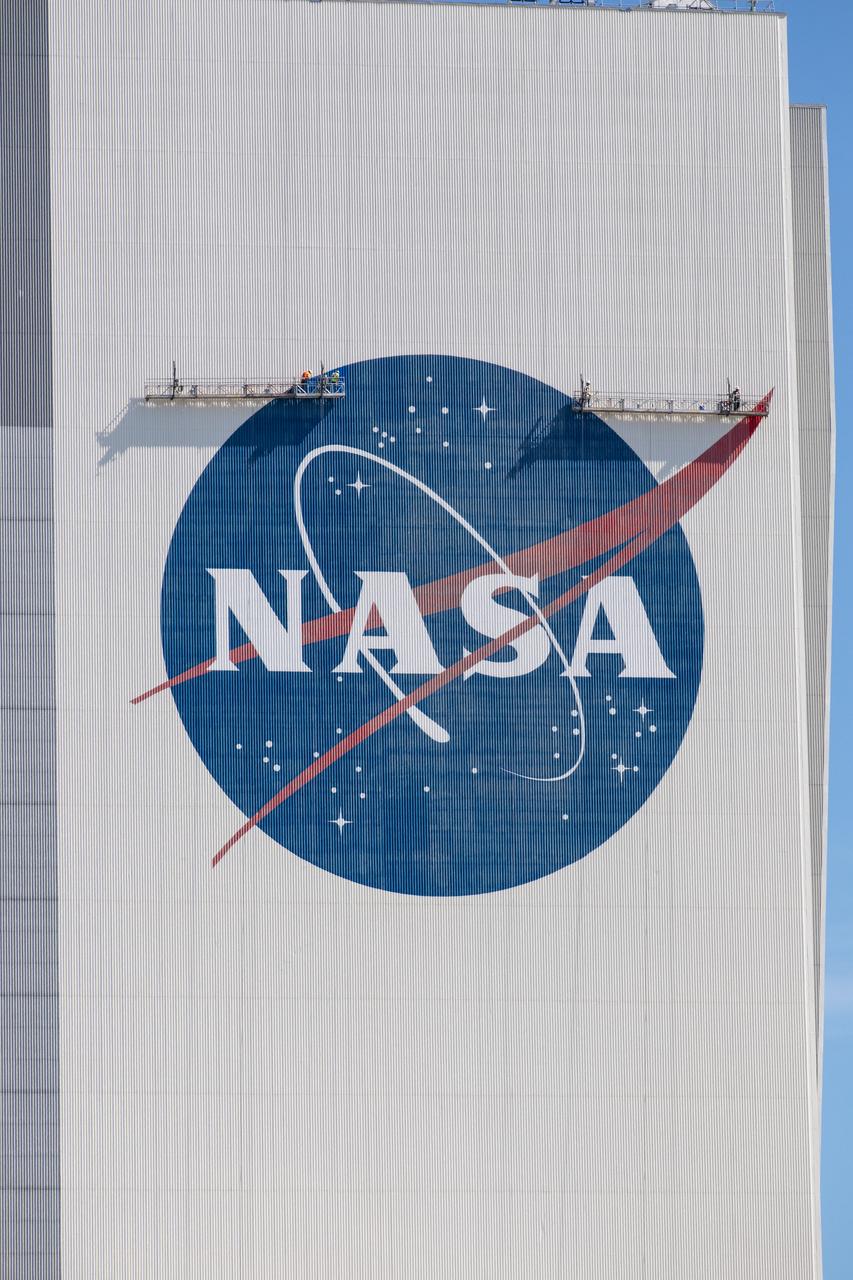 Painting of the NASA logo, also called the meatball, is underway on the 525-foot-tall Vehicle Assembly Building (VAB) at the agency’s Kennedy Space Center in Florida on May 8, 2020. HM2 and H.I.S. Painting of Titusville, Florida, are repainting the meatball and the American Flag on the iconic building. High Bay 3 inside the VAB has been upgraded with 10 new levels of work platforms that will surround and provide access for service and processing of NASA's Space Launch System (SLS) rocket and Orion spacecraft. Exploration Ground Systems is overseeing upgrades to the VAB to support the launch of the SLS and Orion for Artemis missions. Under the Artemis program, NASA will send the first woman and next man to the Moon.