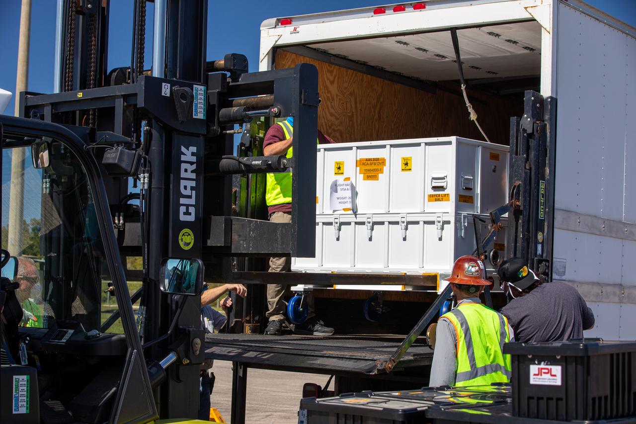 Workers use a special handling device to offload the Adaptive Caching Assembly (ACA) for NASA’s Mars Perseverance rover from the agency’s C-130 aircraft at Kennedy Space Center’s Launch and Landing Facility in Florida on May 11, 2020. The ACA consists of seven motors and more than 3,000 parts, all working in unison to collect samples from the surface of Mars. A chief component of the assembly is the Sample Handling Arm, which will move sample tubes to the main robotic arm's coring drill and then transfer the filled sample tubes into a space to be sealed and stored. The Mars Perseverance rover is scheduled to launch in mid-July atop a United Launch Alliance Atlas V 541 rocket from Pad 41 at nearby Cape Canaveral Air Force Station. The rover is part of NASA’s Mars Exploration Program, a long-term effort of robotic exploration of the Red Planet. The rover will search for habitable conditions in the ancient past and signs of past microbial life on Mars. The Launch Services Program at Kennedy is responsible for launch management.