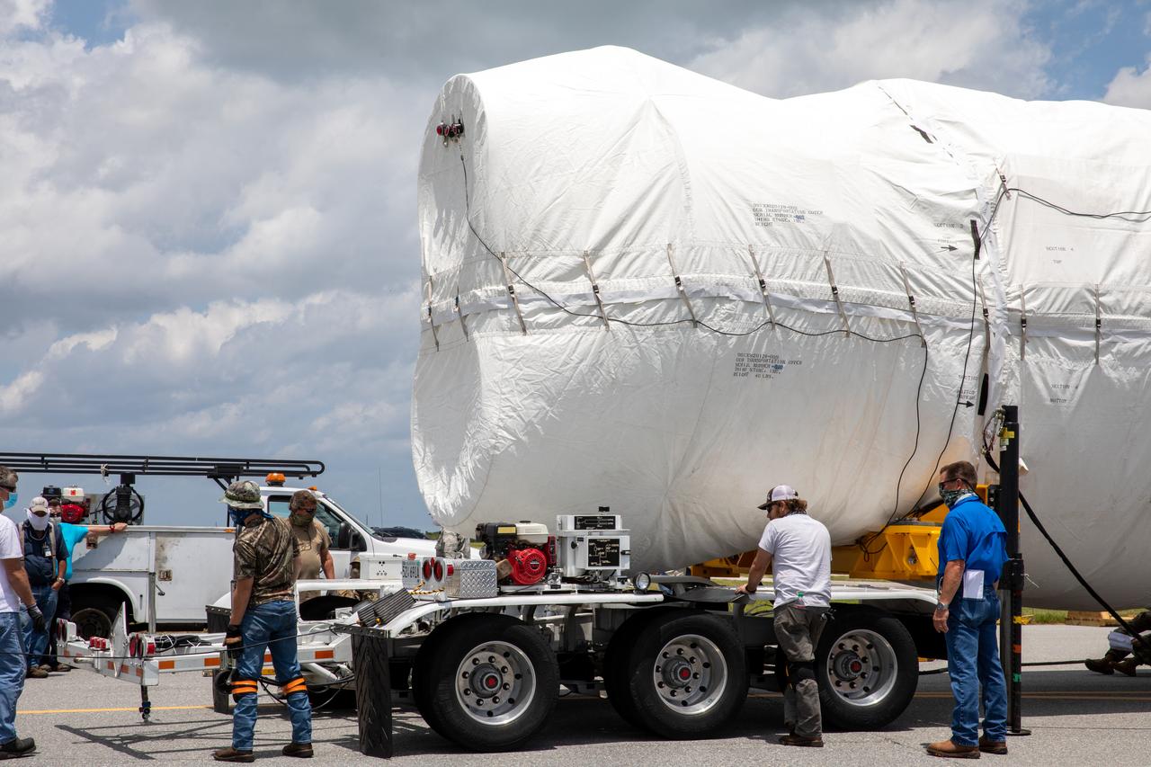 The United Launch Alliance booster for NASA’s Mars Perseverance rover is secured on a flatbed truck after being offloaded from the Antonov 124 cargo aircraft at the Skid Strip at Cape Canaveral Air Force Station (CCAFS) in Florida on May 19, 2020. The Mars Perseverance rover is scheduled to launch in mid-July atop a United Launch Alliance Atlas V 541 rocket from Pad 41 at CCAFS. The rover is part of NASA’s Mars Exploration Program, a long-term effort of robotic exploration of the Red Planet. The rover will search for habitable conditions in the ancient past and signs of past microbial life on Mars. The Launch Services Program at Kennedy is responsible for launch management. 