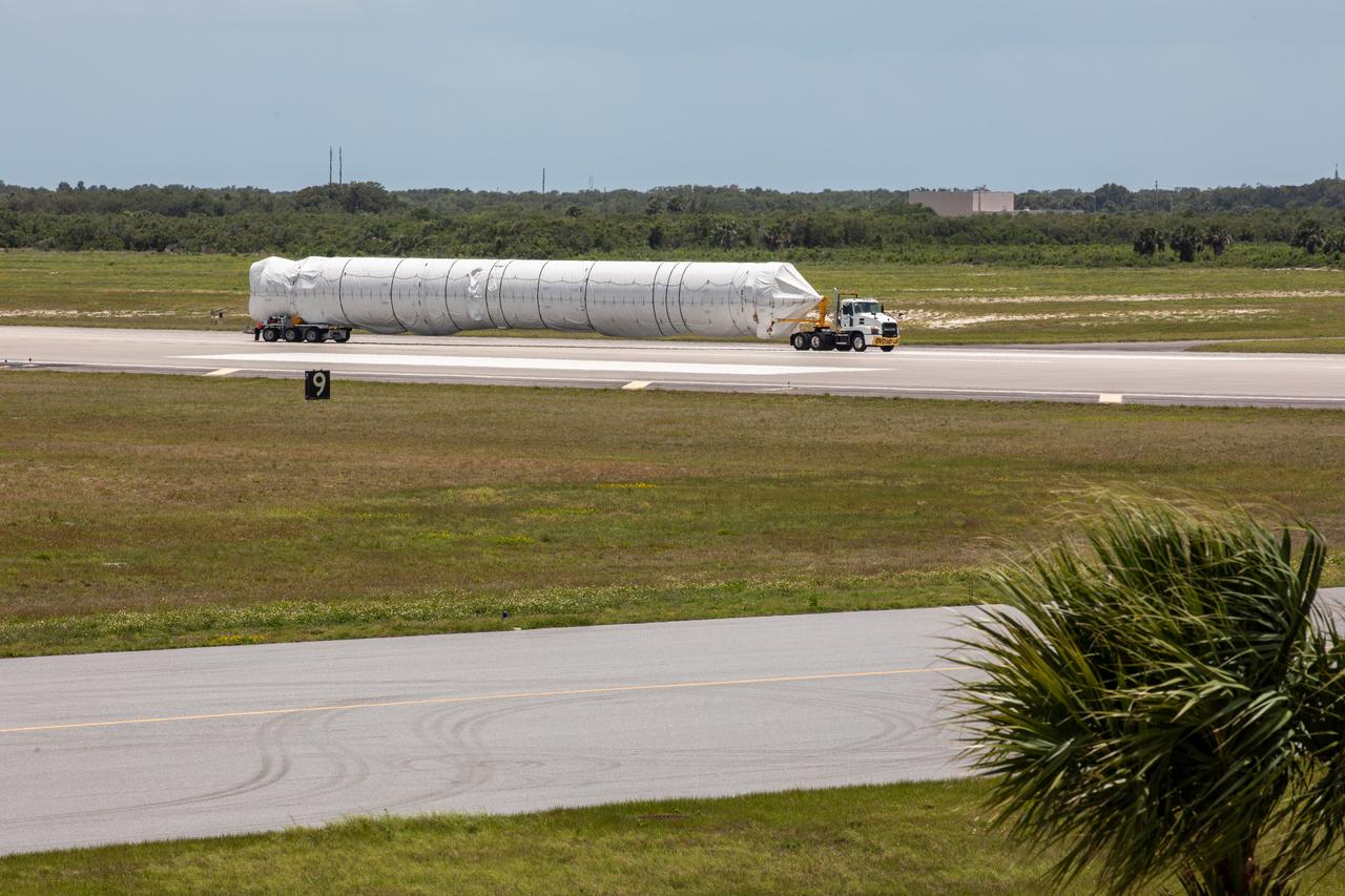 A flatbed truck carrying the United Launch Alliance booster for NASA’s Mars Perseverance rover departs the Skid Strip at Cape Canaveral Air Force Station (CCAFS) in Florida on May 19, 2020. The booster arrived aboard the Antonov 124 cargo aircraft at the Skid Strip on May 18, 2020. The Mars Perseverance rover is scheduled to launch in mid-July atop a United Launch Alliance Atlas V 541 rocket from Pad 41 at CCAFS. The rover is part of NASA’s Mars Exploration Program, a long-term effort of robotic exploration of the Red Planet. The rover will search for habitable conditions in the ancient past and signs of past microbial life on Mars. The Launch Services Program at Kennedy is responsible for launch management.