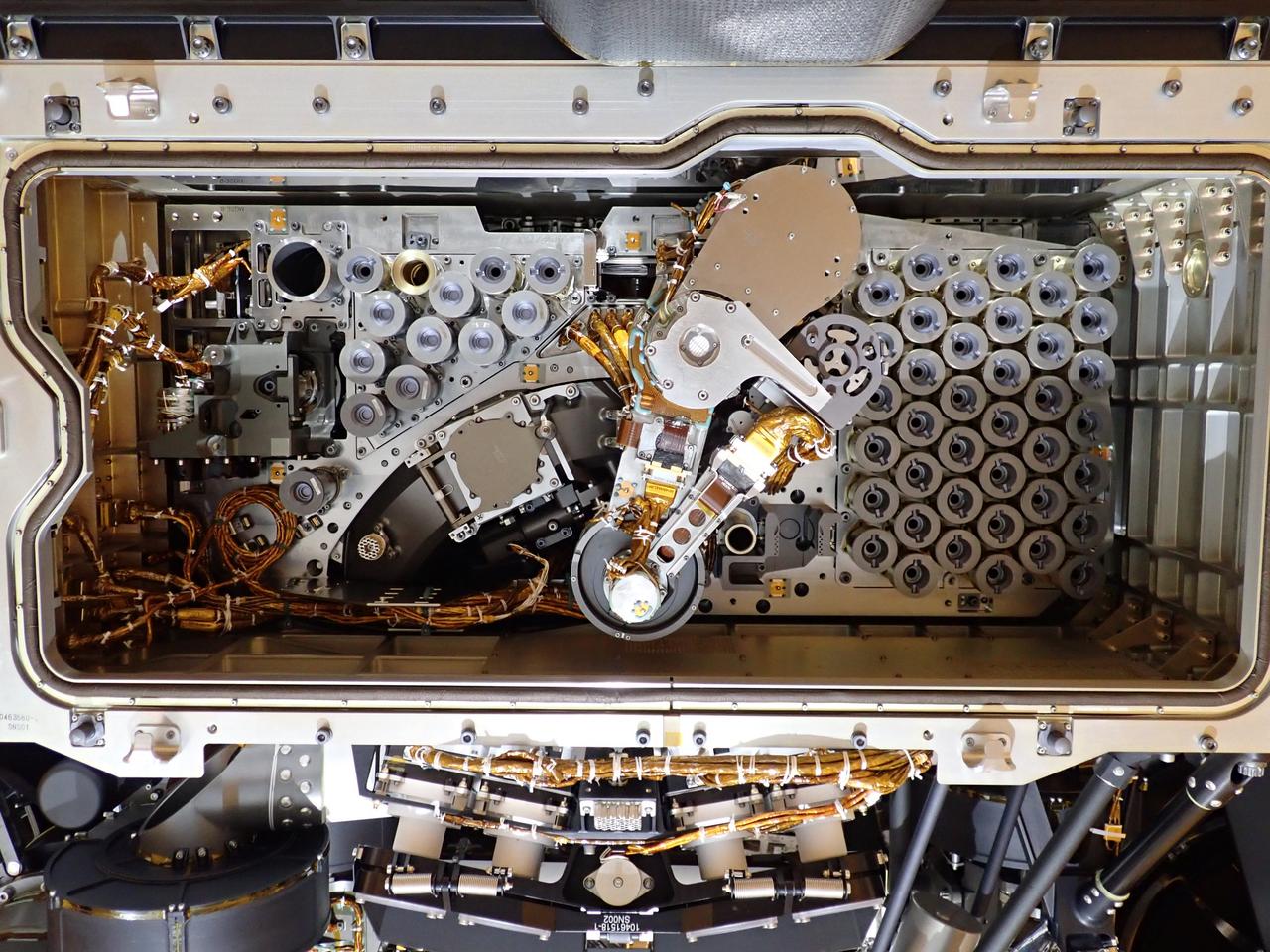 Inside the Payload Hazardous Servicing Facility at NASA’s Kennedy Space Center in Florida, the Sample Caching System Sterile Flight Model hardware was installed on the Mars Perseverance rover on May 21, 2020. The system includes 39 sample tubes. Each tube is sheathed in a gold-colored cylindrical enclosure to protect it from contamination. Perseverance rover will carry 43 sample tubes in total to Mars' Jezero Crater. The Mars Perseverance rover is scheduled to launch in mid-July atop a United Launch Alliance Atlas V 541 rocket from Pad 41 at nearby Cape Canaveral Air Force Station. The rover is part of NASA’s Mars Exploration Program, a long-term effort of robotic exploration of the Red Planet. The rover will search for habitable conditions in the ancient past and signs of past microbial life on Mars. The Launch Services Program at Kennedy is responsible for launch management.