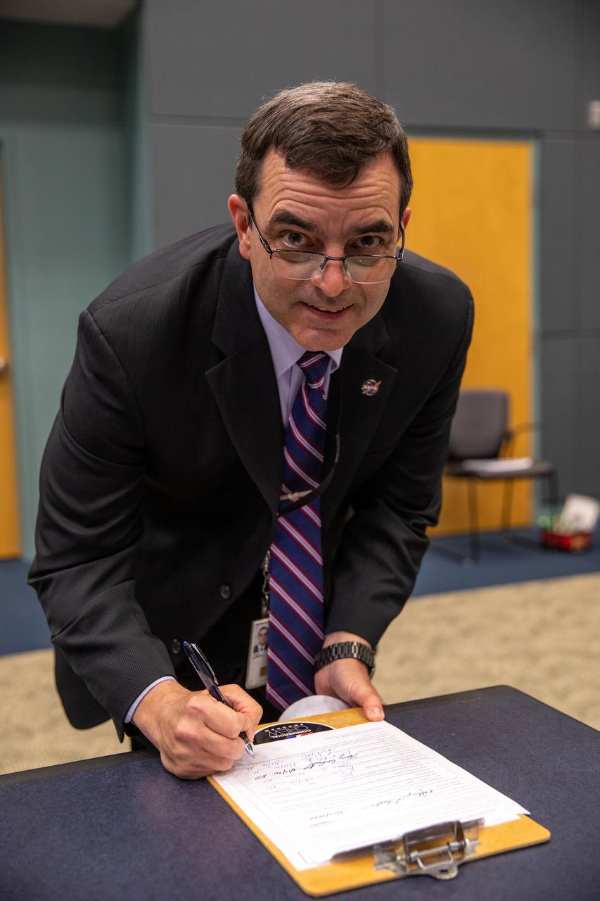 On May 22, 2020, inside the Operations Support Building II at NASA’s Kennedy Space Center in Florida, NASA Chief Health and Medical Officer J.D. Polk signs the official document denoting the agency and SpaceX are a ‘Go’ for the upcoming Demo-2 launch, following the conclusion of the flight readiness review. A SpaceX Falcon 9 rocket and Crew Dragon spacecraft will carry NASA astronauts Robert Behnken and Douglas Hurley to the International Space Station as part of the agency’s Commercial Crew Program, returning human spaceflight capability to the U.S. after nearly a decade. Launch is slated for 4:33 p.m. EDT on Wednesday, May 27, from Kennedy’s Launch Complex 39A.