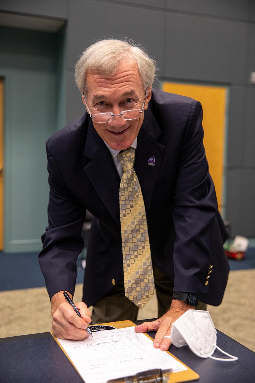 On May 22, 2020, inside the Operations Support Building II at NASA’s Kennedy Space Center in Florida, NASA Chief of Safety and Mission Assurance Terrence Wilcutt signs the official document denoting the agency and SpaceX are a ‘Go’ for the upcoming Demo-2 launch, following the conclusion of the flight readiness review. A SpaceX Falcon 9 rocket and Crew Dragon spacecraft will carry NASA astronauts Robert Behnken and Douglas Hurley to the International Space Station as part of the agency’s Commercial Crew Program, returning human spaceflight capability to the U.S. after nearly a decade. Launch is slated for 4:33 p.m. EDT on Wednesday, May 27, from Kennedy’s Launch Complex 39A.