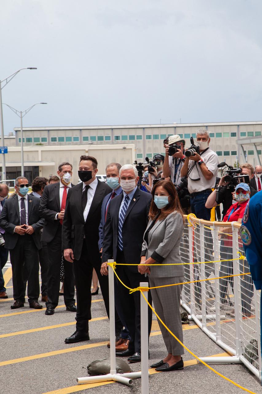 From left, SpaceX CEO and Chief Designer Elon Musk, NASA Administrator Jim Bridenstine, Vice President Mike Pence and second lady Karen Pence wait to greet NASA astronauts Robert Behnken and Douglas Hurley outside of the Neil A. Armstrong Operations and Checkout Building at the agency’s Kennedy Space Center in Florida ahead of NASA’s SpaceX Demo-2 launch. The launch, initially scheduled for May 27, 2020, was scrubbed due to unfavorable weather conditions around Launch Complex 39A. The next launch attempt will be Saturday, May 30. Liftoff of the SpaceX Falcon 9 rocket and Crew Dragon spacecraft is scheduled for 3:22 p.m. EDT from historic Launch Complex 39A. Behnken and Hurley will be the first astronauts to launch to the International Space Station from U.S. soil since the end of the Space Shuttle Program in 2011. Part of NASA’s Commercial Crew Program, this will be SpaceX’s final flight test, paving the way for the agency to certify the crew transportation system for regular, crewed flights to the orbiting laboratory.