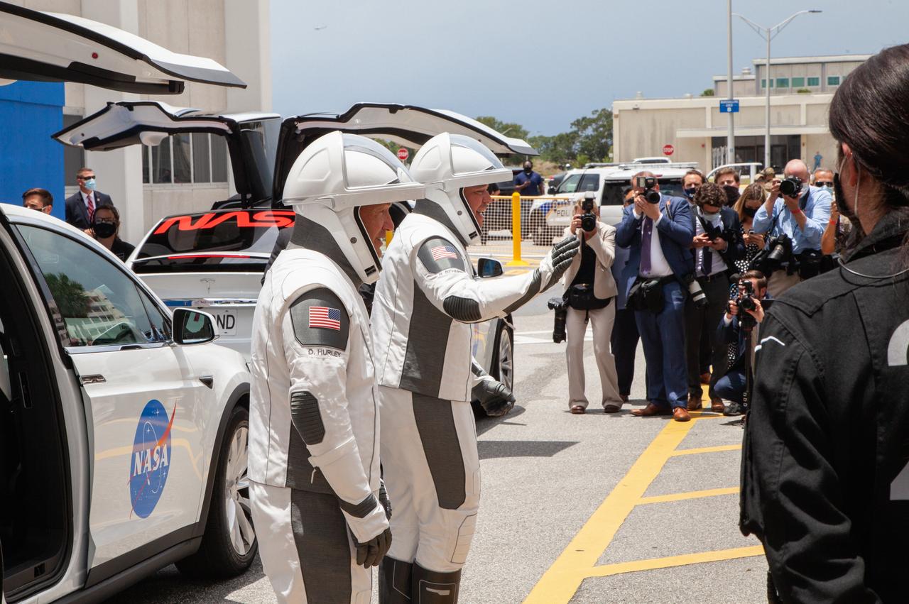 NASA astronauts Douglas Hurley (left) and Robert Behnken speak to their families before entering the Tesla Model X that will transport them from the Neil A. Armstrong Operations and Checkout Building to historic Launch Complex 39A at the Kennedy Space Center in Florida for NASA’s SpaceX Demo-2 mission. The launch, initially scheduled for May 27, 2020, was scrubbed due to unfavorable weather conditions around Launch Complex 39A. The next launch attempt will be Saturday, May 30. Liftoff of the SpaceX Falcon 9 rocket and Crew Dragon spacecraft is scheduled for 3:22 p.m. EDT from historic Launch Complex 39A. Behnken and Hurley will be the first astronauts to launch to the International Space Station from U.S. soil since the end of the Space Shuttle Program in 2011. Part of NASA’s Commercial Crew Program, this will be SpaceX’s final flight test, paving the way for the agency to certify the crew transportation system for regular, crewed flights to the orbiting laboratory.