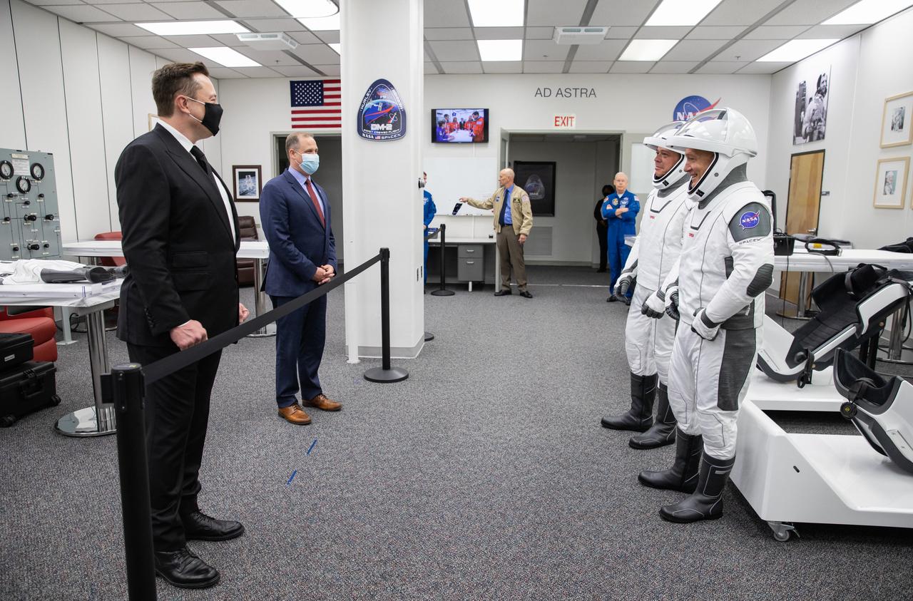 Behind the rope, SpaceX CEO and Chief Designer Elon Musk (left) and NASA Administrator Jim Bridenstine greet NASA astronauts Robert Behnken (left) and Douglas Hurley inside the Astronaut Crew Quarters in the Neil A. Armstrong Operations and Checkout Building at NASA’s Kennedy Space Center in Florida ahead of the agency’s SpaceX Demo-2 mission. The launch, initially scheduled for May 27, 2020, was scrubbed due to unfavorable weather conditions around Launch Complex 39A. The next launch attempt will be Saturday, May 30. Liftoff of the SpaceX Falcon 9 rocket and Crew Dragon spacecraft is scheduled for 3:22 p.m. EDT from historic Launch Complex 39A. Behnken and Hurley will be the first astronauts to launch to the International Space Station from U.S. soil since the end of the Space Shuttle Program in 2011. Part of NASA’s Commercial Crew Program, this will be SpaceX’s final flight test, paving the way for the agency to certify the crew transportation system for regular, crewed flights to the orbiting laboratory.
