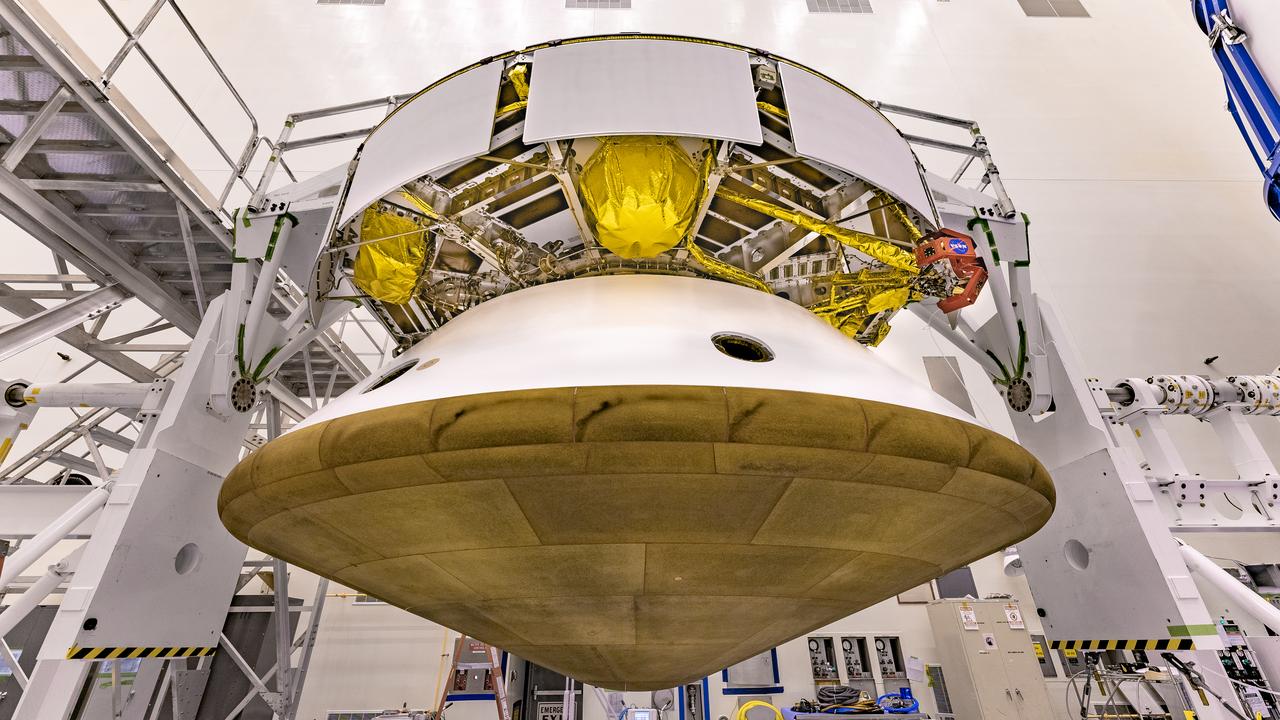 Inside the Payload Hazardous Servicing Facility at NASA’s Kennedy Space Center in Florida, the Backshell-Powered Descent Vehicle and Entry Vehicle assemblies are being attached to the Mars Perseverance rover on May 28, 2020. The cone-shaped backshell contains the parachute, and along with the mission’s heat shield, provides protection for the rover and descent stage during Martian atmospheric entry. The Mars Perseverance rover is scheduled to launch on July 20 atop a United Launch Alliance Atlas V 541 rocket from Pad 41 at nearby Cape Canaveral Air Force Station. The rover is part of NASA’s Mars Exploration Program, a long-term effort of robotic exploration of the Red Planet. The rover will search for habitable conditions in the ancient past and signs of past microbial life on Mars. The Launch Services Program at Kennedy is responsible for launch management.