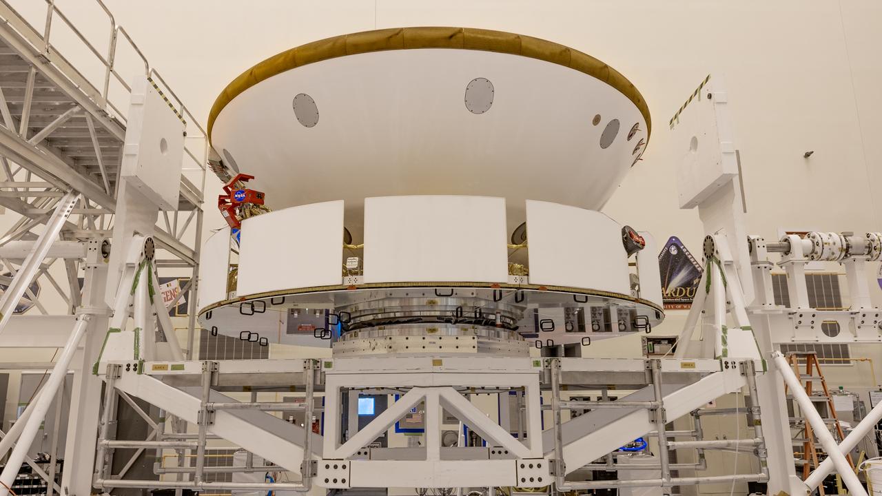 Inside the Payload Hazardous Servicing Facility at NASA’s Kennedy Space Center in Florida, the Backshell-Powered Descent Vehicle and Entry Vehicle assemblies are being attached to the Mars Perseverance rover on May 29, 2020. The cone-shaped backshell contains the parachute, and along with the mission’s heat shield, provides protection for the rover and descent stage during Martian atmospheric entry. The Mars Perseverance rover is scheduled to launch on July 20 atop a United Launch Alliance Atlas V 541 rocket from Pad 41 at nearby Cape Canaveral Air Force Station. The rover is part of NASA’s Mars Exploration Program, a long-term effort of robotic exploration of the Red Planet. The rover will search for habitable conditions in the ancient past and signs of past microbial life on Mars. The Launch Services Program at Kennedy is responsible for launch management.