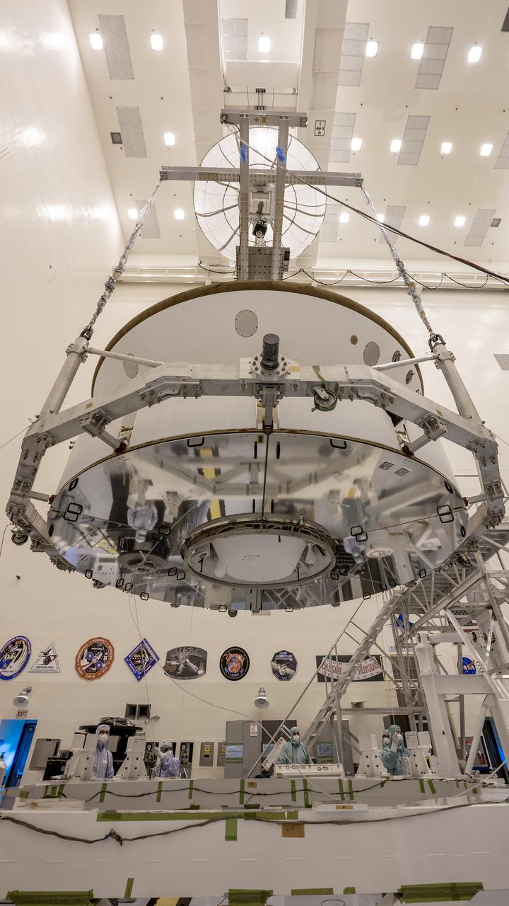 Inside the Payload Hazardous Servicing Facility at NASA’s Kennedy Space Center in Florida, the Mars Perseverance rover, with its Backshell-Powered Descent Vehicle and Entry Vehicle assemblies attached, is lifted by crane on May 29, 2020. The cone-shaped backshell contains the parachute, and along with the mission’s heat shield, provides protection for the rover and descent stage during Martian atmospheric entry. The Mars Perseverance rover is scheduled to launch on July 20 atop a United Launch Alliance Atlas V 541 rocket from Pad 41 at nearby Cape Canaveral Air Force Station. The rover is part of NASA’s Mars Exploration Program, a long-term effort of robotic exploration of the Red Planet. The rover will search for habitable conditions in the ancient past and signs of past microbial life on Mars. The Launch Services Program at Kennedy is responsible for launch management.