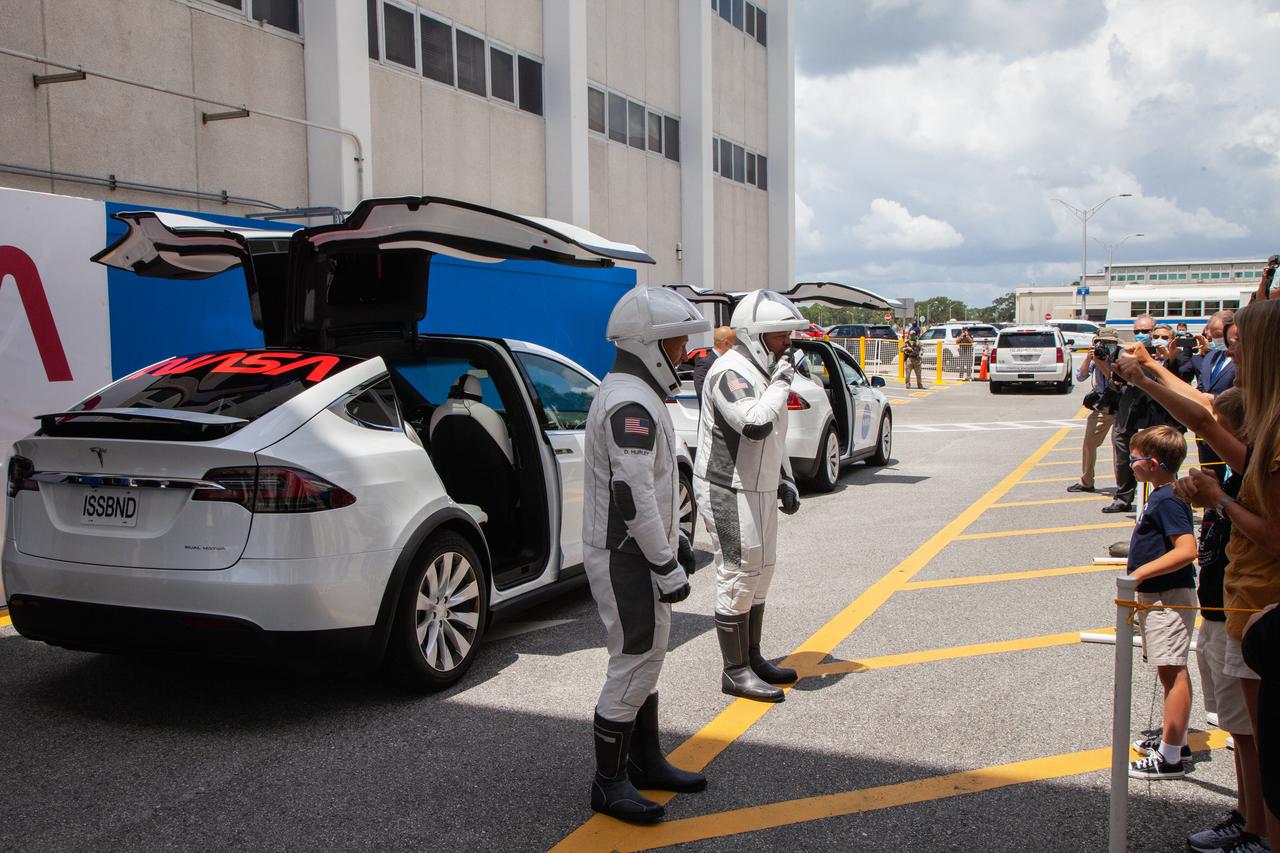 NASA astronauts Douglas Hurley (left) and Robert Behnken speak to their families before entering the Tesla Model X that will transport them from the Neil A. Armstrong Operations and Checkout Building to historic Launch Complex 39A at the Kennedy Space Center in Florida for NASA’s SpaceX Demo-2 launch on May 30, 2020. The SpaceX Falcon 9 rocket and Crew Dragon spacecraft lifted off at 3:22 p.m. EDT. Behnken and Hurley are the first astronauts to launch to the International Space Station from U.S. soil since the end of the Space Shuttle Program in 2011. Part of NASA’s Commercial Crew Program, this will be SpaceX’s final flight test, paving the way for the agency to certify the crew transportation system for regular, crewed flights to the orbiting laboratory.