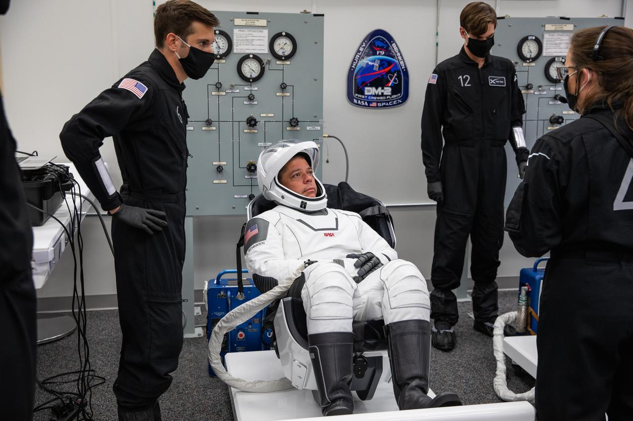 Inside the suit-up room in the Neil A. Armstrong Operations and Checkout Building at NASA’s Kennedy Space Center in Florida, NASA astronaut Robert Behnken dons his spacesuit ahead of the agency’s SpaceX Demo-2 launch on May 30, 2020. Behnken and crewmate Douglas Hurley are the first astronauts to launch to the International Space Station from U.S. soil since the end of the Space Shuttle Program in 2011. The SpaceX Falcon 9 rocket and Crew Dragon spacecraft lifted off at 3:22 p.m. EDT from historic Launch Complex 39A. Part of NASA’s Commercial Crew Program, this will be SpaceX’s final flight test, paving the way for the agency to certify the crew transportation system for regular, crewed flights to the orbiting laboratory.