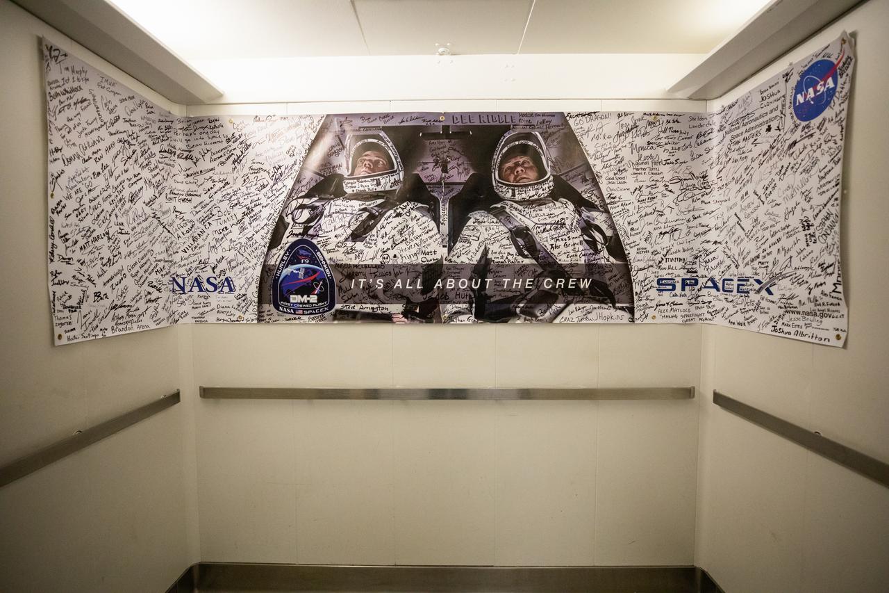 A NASA and SpaceX Demo-2 mission poster, containing a photograph of NASA astronauts Robert Behnken and Douglas Hurley and signatures from the launch team, is photographed inside an elevator in the Neil A. Armstrong Operations and Checkout Building at the agency’s Kennedy Space Center in Florida on May 30, 2020, ahead of the Demo-2 launch. The SpaceX Falcon 9 rocket and Crew Dragon spacecraft lifted off at 3:22 p.m. EDT from historic Launch Complex 39A. Behnken and Hurley are the first astronauts to launch to the International Space Station from U.S. soil since the end of the Space Shuttle Program in 2011. Part of NASA’s Commercial Crew Program, this will be SpaceX’s final flight test, paving the way for the agency to certify the crew transportation system for regular, crewed flights to the orbiting laboratory.