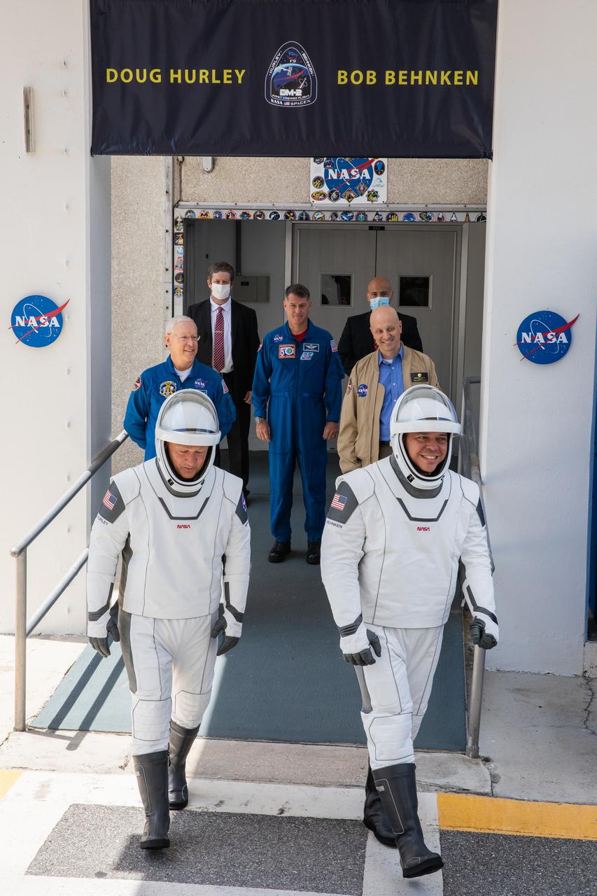 NASA astronauts Douglas Hurley (left) and Robert Behnken exit the Neil A. Armstrong Operations and Checkout Building at the agency’s Kennedy Space Center in Florida on May 30, 2020, in preparation for transport to Launch Complex 39A ahead of embarking on NASA’s SpaceX Demo-2 mission to the International Space Station. The SpaceX Falcon 9 rocket and Crew Dragon spacecraft lifted off at 3:22 p.m. EDT. Behnken and Hurley are the first astronauts to launch to the space station from U.S. soil since the end of the Space Shuttle Program in 2011. Part of NASA’s Commercial Crew Program, this will be SpaceX’s final flight test, paving the way for the agency to certify the crew transportation system for regular, crewed flights to the orbiting laboratory.