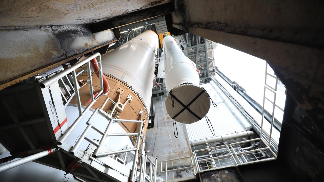 In this view looking up inside the Vertical Integration Facility at Space Launch Complex 41 at Cape Canaveral Air Force Station in Florida, the second of four solid rocket boosters (SRB) for the United Launch Alliance Atlas V 541 rocket is lowered by crane into position on June 3, 2020. The SRB will be mated to the Atlas V booster. NASA’s Mars 2020 mission with the Perseverance rover is scheduled to launch on July 20, 2020, atop the Atlas V rocket from Pad 41. The rover is part of NASA’s Mars Exploration Program, a long-term effort of robotic exploration of the Red Planet. The rover’s seven instruments will search for habitable conditions in the ancient past and signs of past microbial life on Mars. The Launch Services Program at Kennedy is responsible for launch management.