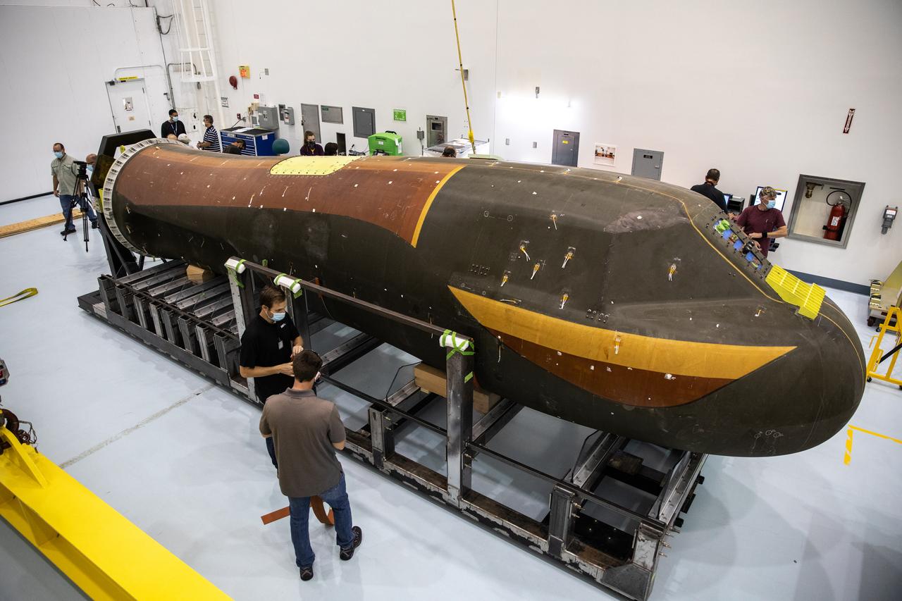 Inside the low bay of the Space Station Processing Facility at NASA’s Kennedy Space Center in Florida, workers assist as Sierra Nevada Corporation’s (SNC) Dream Chaser pressure test article on its support structure is lowered by crane on June 3, 2020, for its move into the high bay. The test article was shipped from Louisville, Colorado. It is similar to the actual pressurized cabin being used in the Dream Chaser spaceplane for Commercial Resupply Services-2 (CRS-2) missions. NASA selected Dream Chaser to provide cargo delivery, return and disposal service for the International Space Station under the CRS-2 contract. The test article will remain at Kennedy while SNC engineers use it to develop and verify refurbishment operations that will be used on Dream Chaser between flights. 