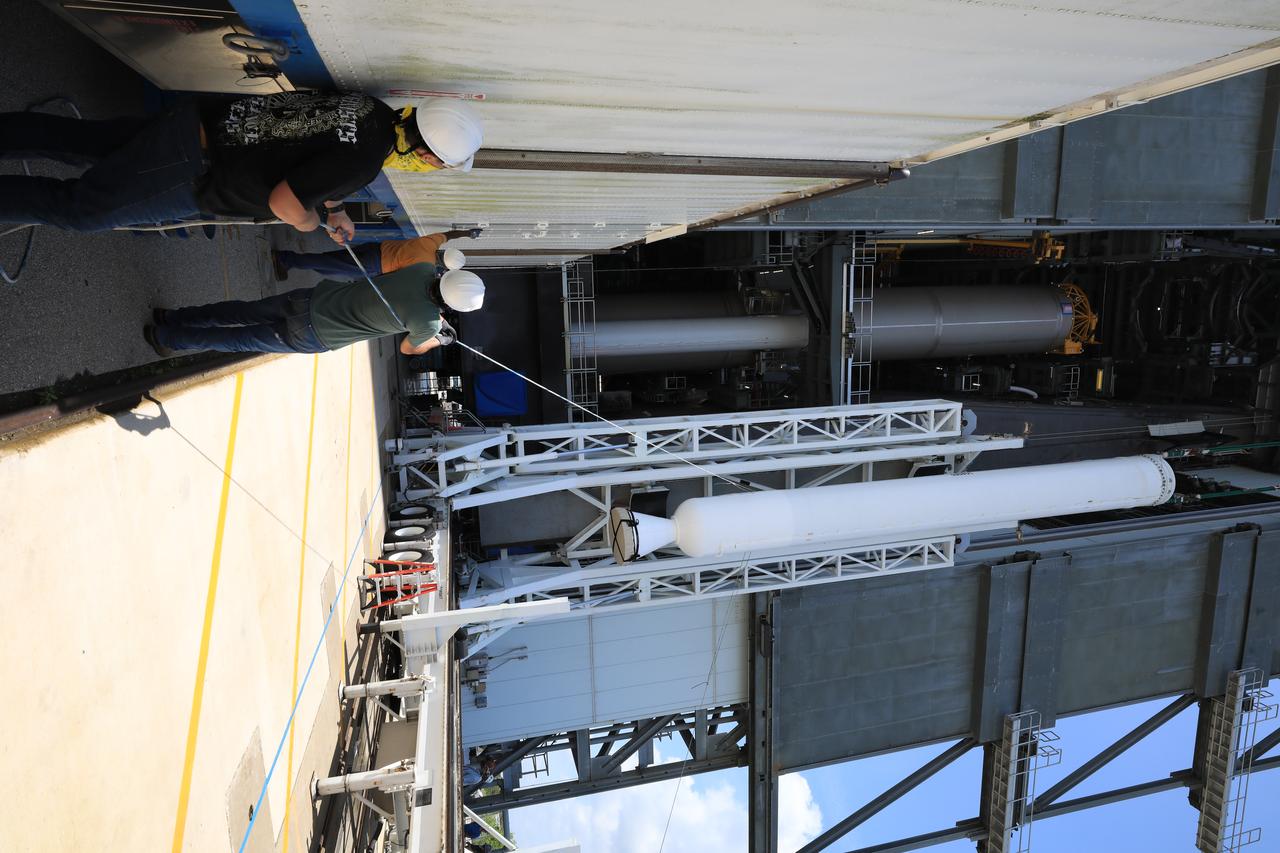 A crane is attached to the third of four solid rocket boosters (SRB) for the United Launch Alliance Atlas V 541 rocket to lift it into the Vertical Integration Facility (VIF) at Space Launch Complex 41 at Cape Canaveral Air Force Station (CCAFS) in Florida on June 8, 2020. The SRB will be lifted up and mated to the Atlas V booster in the VIF. NASA’s Mars 2020 mission with the Perseverance rover is scheduled to launch on July 20, 2020, atop the Atlas V rocket from Pad 41. The rover is part of NASA’s Mars Exploration Program, a long-term effort of robotic exploration of the Red Planet. The rover’s seven instruments will search for habitable conditions in the ancient past and signs of past microbial life on Mars. The Launch Services Program at Kennedy is responsible for launch management.