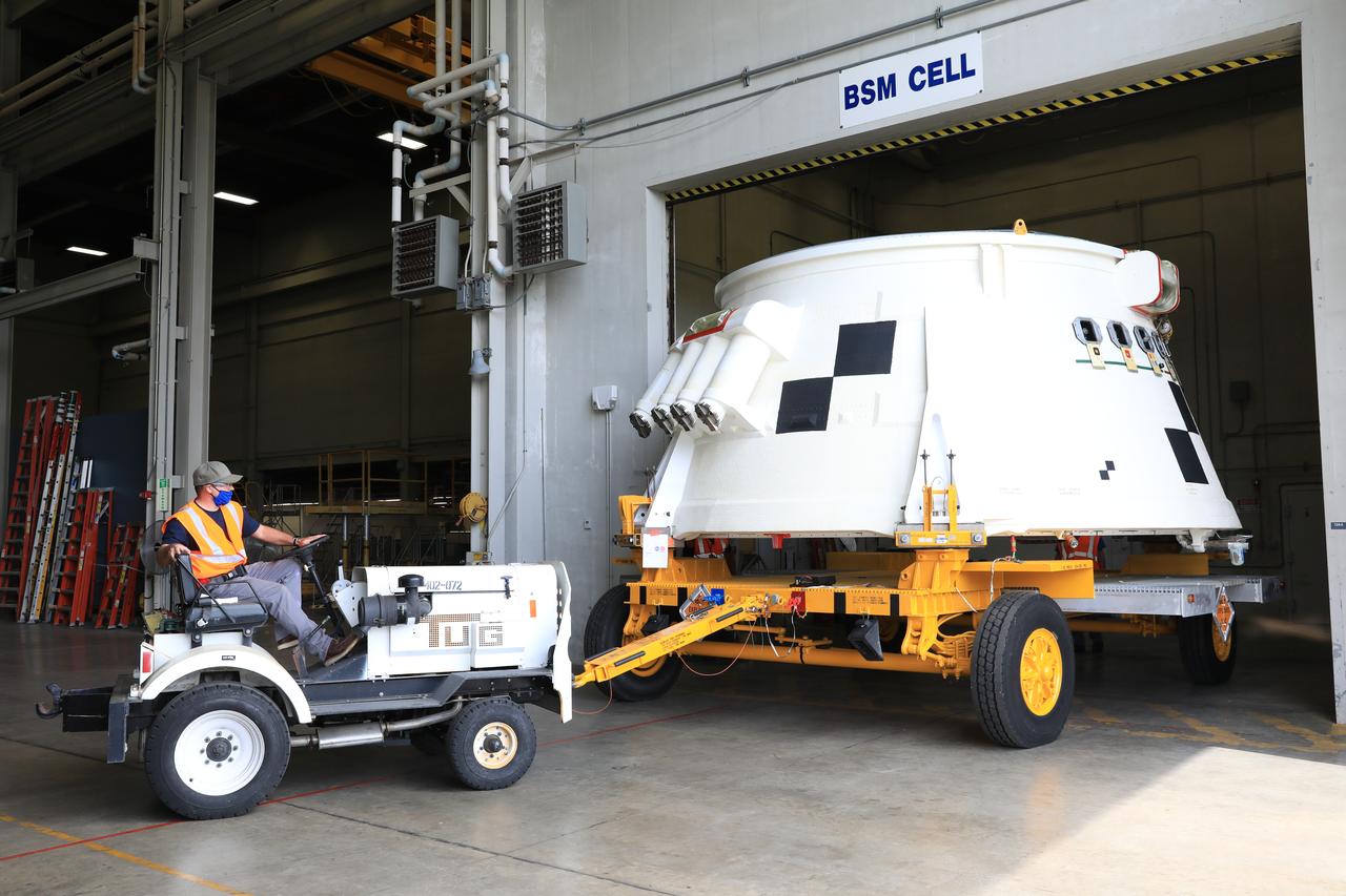 Inside the Booster Fabrication Facility at NASA's Kennedy Space Center in Florida, the Artemis I aft skirts for the agency's Space Launch System (SLS) rocket’s twin solid rocket boosters are being readied for their move to the Rotation, Processing and Surge Facility (RPSF) on June 9, 2020. In view, the left aft skirt assembly is attached to a move vehicle and moved out of a test cell. The aft skirts were refurbished by Northrop Grumman. They house the thrust vector control system, which controls 70 percent of the steering during initial ascent of the SLS rocket. The segments will remain in the RPSF until ready for stacking with the forward and aft parts of the boosters on the mobile launcher in High Bay 3 of the Vehicle Assembly Building. Through the Artemis Program, NASA is working to land the first woman and next man on the Moon by 2024. 