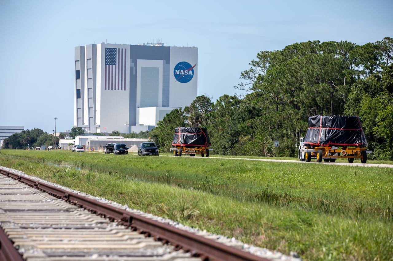 The Artemis I aft skirts for NASA’s Space Launch System (SLS) rocket’s twin solid rocket boosters are moved along the road to the Rotation, Processing and Surge Facility (RPSF) at the agency’s Kennedy Space Center in Florida on June 10, 2020. The aft skirts were refurbished by Northrop Grumman. They house the thrust vector control system, which controls 70 percent of the steering during initial ascent of the SLS rocket. The aft skirts will remain in the RPSF until ready for stacking with the forward and aft parts of the boosters on the mobile launcher in High Bay 3 of the Vehicle Assembly Building. Through the Artemis Program, NASA is working to land the first woman and next man on the Moon by 2024. 
