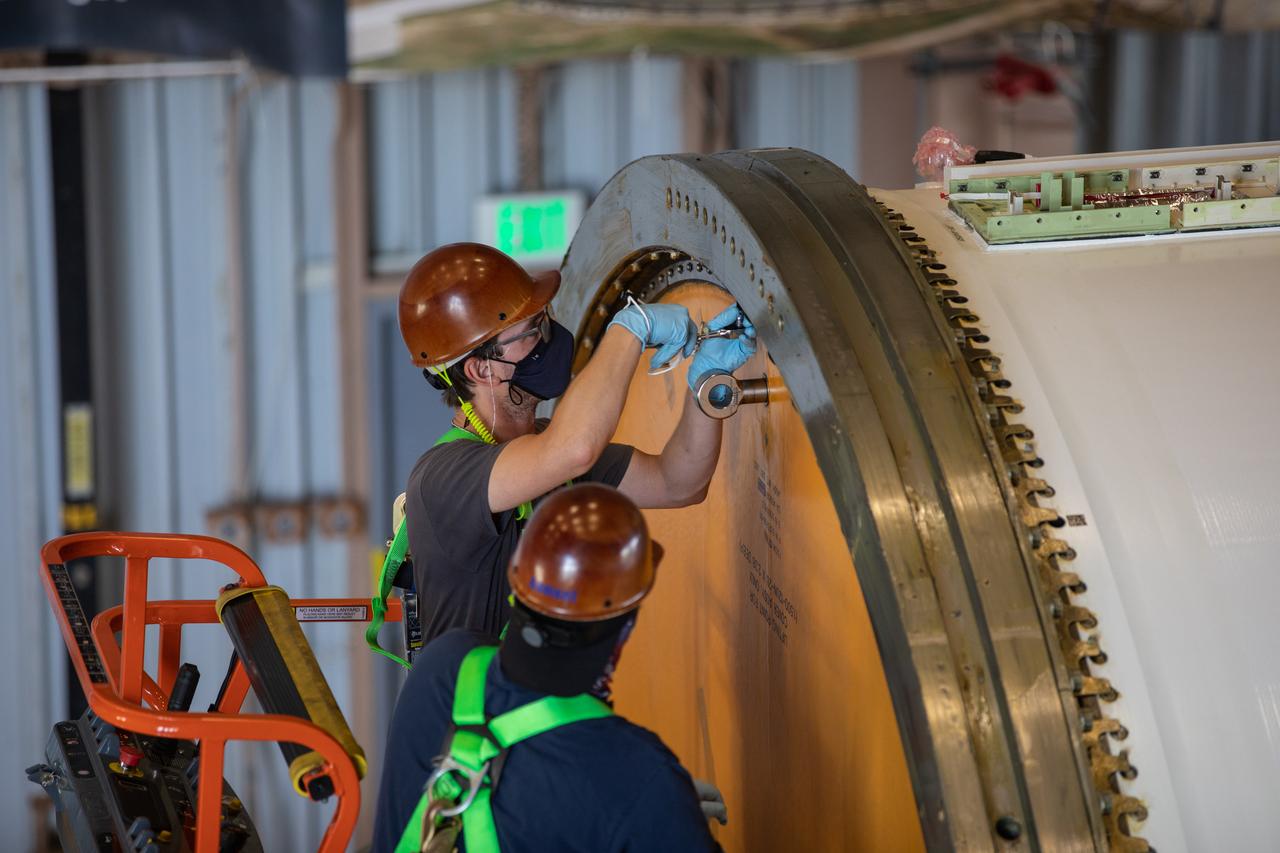 Technicians ready two NASA Space Launch System (SLS) solid rocket boosters for mating to the rocket’s two aft skirts on June 16, 2020, inside Kennedy Space Center’s Rotation, Processing and Surge Facility. Together, the twin boosters provide more than 75 percent of the total SLS thrust at launch. Manufactured by Northrop Grumman in Promontory, Utah, the boosters arrived at Kennedy via train. The cross-country journey was an important milestone for the agency’s Artemis I launch. The first in a series of increasingly complex missions, Artemis I will test the Orion spacecraft and SLS as an integrated system prior to crewed missions to the Moon. Once the boosters are mated with the aft skirts, they will be moved to the Vehicle Assembly Building for stacking on the mobile launcher.