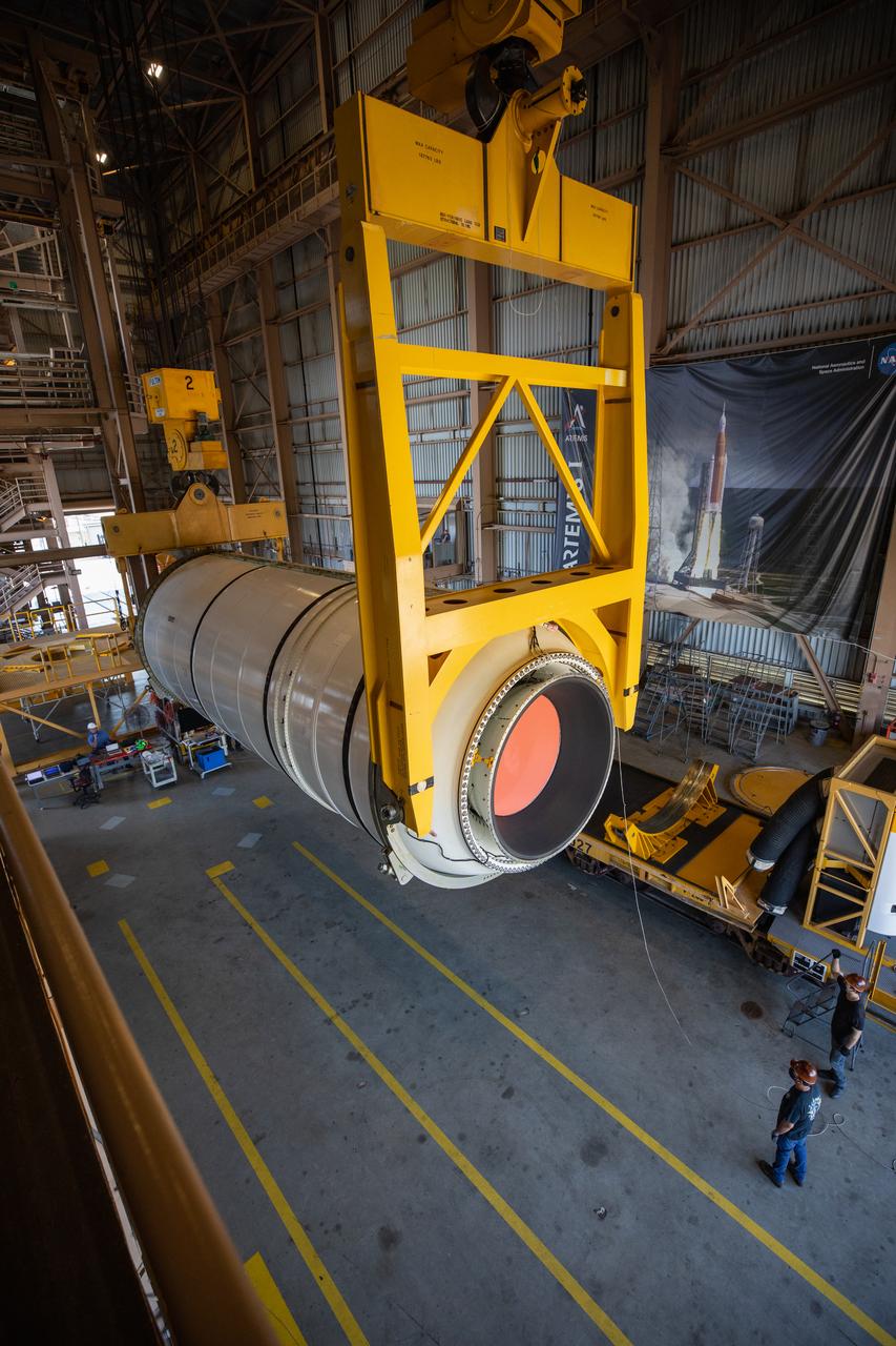 Inside the Rotation, Processing and Surge Facility (RPSF) at NASA’s Kennedy Space Center in Florida, technicians lift the right aft motor segment – one of five segments that make up one of two solid rocket boosters for the agency’s Space Launch System (SLS) – onto an inspection stand on June 23, 2020. While in the RPSF, the boosters will be mated to the rocket’s two aft skirts before they are moved to the Vehicle Assembly Building for stacking on the mobile launcher. The boosters, manufactured by Northrop Grumman in Utah, recently arrived at Kennedy for processing ahead of the Artemis I launch. Together, the twin boosters provide more than 75 percent of the total SLS thrust at launch. The first in a series of increasingly complex missions, Artemis I will test the Orion spacecraft and SLS as an integrated system ahead of crewed flights to the Moon.  