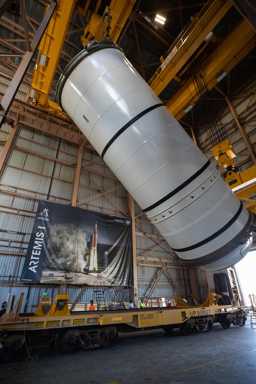 Inside the Rotation, Processing and Surge Facility (RPSF) at NASA’s Kennedy Space Center in Florida, technicians lift the right aft motor segment – one of five segments that make up one of two solid rocket boosters for the agency’s Space Launch System (SLS) – onto an inspection stand on June 23, 2020. While in the RPSF, the boosters will be mated to the rocket’s two aft skirts before they are moved to the Vehicle Assembly Building for stacking on the mobile launcher. The boosters, manufactured by Northrop Grumman in Utah, recently arrived at Kennedy for processing ahead of the Artemis I launch. Together, the twin boosters provide more than 75 percent of the total SLS thrust at launch. The first in a series of increasingly complex missions, Artemis I will test the Orion spacecraft and SLS as an integrated system ahead of crewed flights to the Moon.  