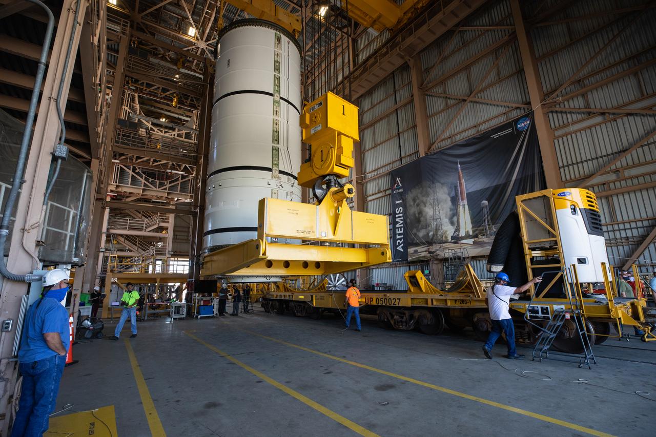 Inside the Rotation, Processing and Surge Facility (RPSF) at NASA’s Kennedy Space Center in Florida, technicians lift the right aft motor segment – one of five segments that make up one of two solid rocket boosters for the agency’s Space Launch System (SLS) – onto an inspection stand on June 23, 2020. While in the RPSF, the boosters will be mated to the rocket’s two aft skirts before they are moved to the Vehicle Assembly Building for stacking on the mobile launcher. The boosters, manufactured by Northrop Grumman in Utah, recently arrived at Kennedy for processing ahead of the Artemis I launch. Together, the twin boosters provide more than 75 percent of the total SLS thrust at launch. The first in a series of increasingly complex missions, Artemis I will test the Orion spacecraft and SLS as an integrated system ahead of crewed flights to the Moon.  