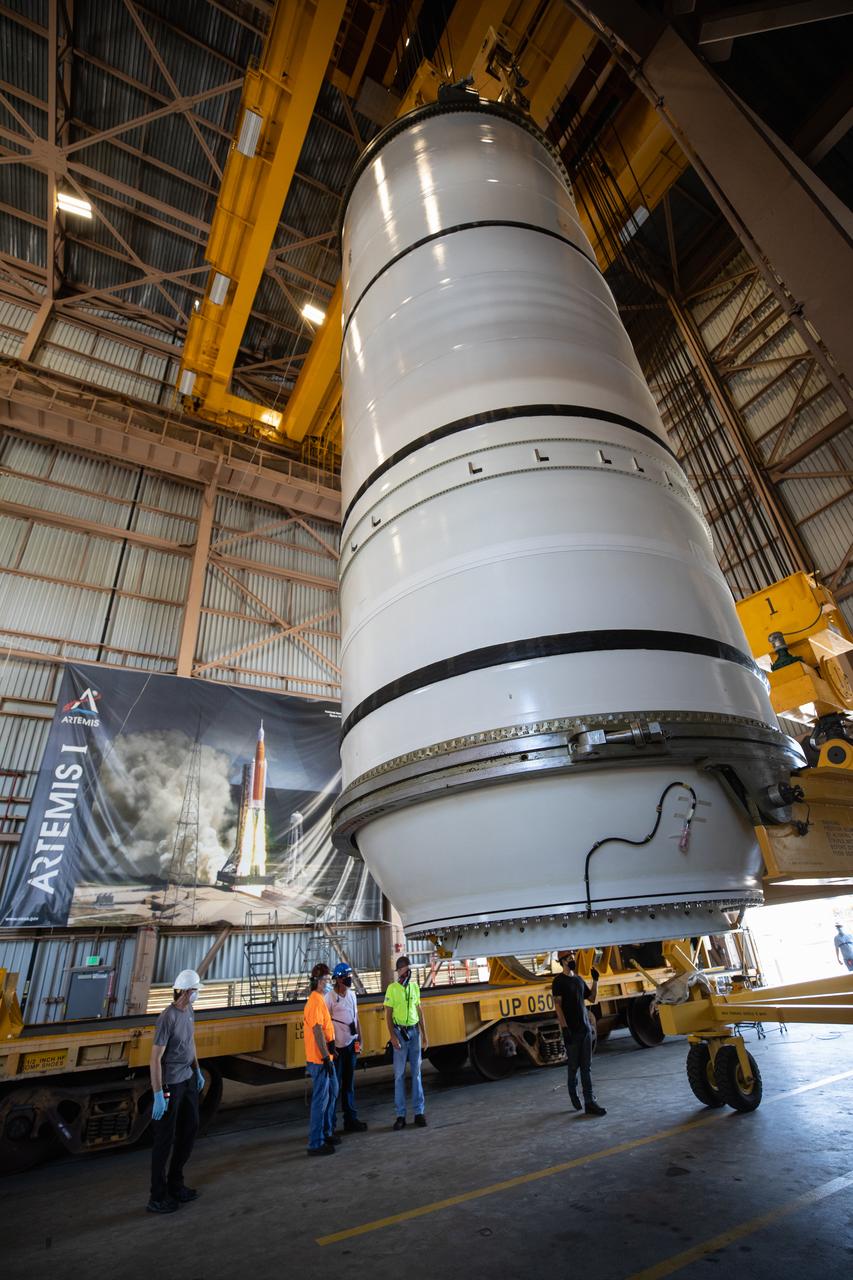 Inside the Rotation, Processing and Surge Facility (RPSF) at NASA’s Kennedy Space Center in Florida, technicians lift the right aft motor segment – one of five segments that make up one of two solid rocket boosters for the agency’s Space Launch System (SLS) – onto an inspection stand on June 23, 2020. While in the RPSF, the boosters will be mated to the rocket’s two aft skirts before they are moved to the Vehicle Assembly Building for stacking on the mobile launcher. The boosters, manufactured by Northrop Grumman in Utah, recently arrived at Kennedy for processing ahead of the Artemis I launch. Together, the twin boosters provide more than 75 percent of the total SLS thrust at launch. The first in a series of increasingly complex missions, Artemis I will test the Orion spacecraft and SLS as an integrated system ahead of crewed flights to the Moon.  