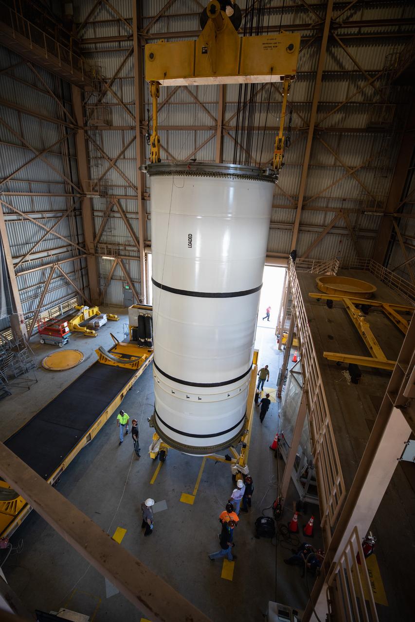 Inside the Rotation, Processing and Surge Facility (RPSF) at NASA’s Kennedy Space Center in Florida, technicians lift the right aft motor segment – one of five segments that make up one of two solid rocket boosters for the agency’s Space Launch System (SLS) – onto an inspection stand on June 23, 2020. While in the RPSF, the boosters will be mated to the rocket’s two aft skirts before they are moved to the Vehicle Assembly Building for stacking on the mobile launcher. The boosters, manufactured by Northrop Grumman in Utah, recently arrived at Kennedy for processing ahead of the Artemis I launch. Together, the twin boosters provide more than 75 percent of the total SLS thrust at launch. The first in a series of increasingly complex missions, Artemis I will test the Orion spacecraft and SLS as an integrated system ahead of crewed flights to the Moon.  