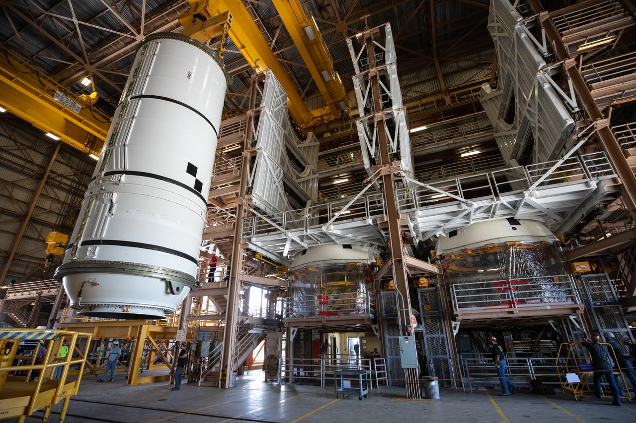 Inside the Rotation, Processing and Surge Facility (RPSF) at NASA’s Kennedy Space Center in Florida, technicians lift the right aft motor segment – one of five segments that make up one of two solid rocket boosters for the agency’s Space Launch System (SLS) – onto an inspection stand on June 23, 2020. While in the RPSF, the boosters will be mated to the rocket’s two aft skirts before they are moved to the Vehicle Assembly Building for stacking on the mobile launcher. The boosters, manufactured by Northrop Grumman in Utah, recently arrived at Kennedy for processing ahead of the Artemis I launch. Together, the twin boosters provide more than 75 percent of the total SLS thrust at launch. The first in a series of increasingly complex missions, Artemis I will test the Orion spacecraft and SLS as an integrated system ahead of crewed flights to the Moon.  