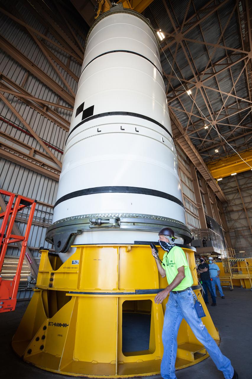 Inside the Rotation, Processing and Surge Facility (RPSF) at NASA’s Kennedy Space Center in Florida, technicians lift the right aft motor segment – one of five segments that make up one of two solid rocket boosters for the agency’s Space Launch System (SLS) – onto an inspection stand on June 23, 2020. While in the RPSF, the boosters will be mated to the rocket’s two aft skirts before they are moved to the Vehicle Assembly Building for stacking on the mobile launcher. The boosters, manufactured by Northrop Grumman in Utah, recently arrived at Kennedy for processing ahead of the Artemis I launch. Together, the twin boosters provide more than 75 percent of the total SLS thrust at launch. The first in a series of increasingly complex missions, Artemis I will test the Orion spacecraft and SLS as an integrated system ahead of crewed flights to the Moon.  