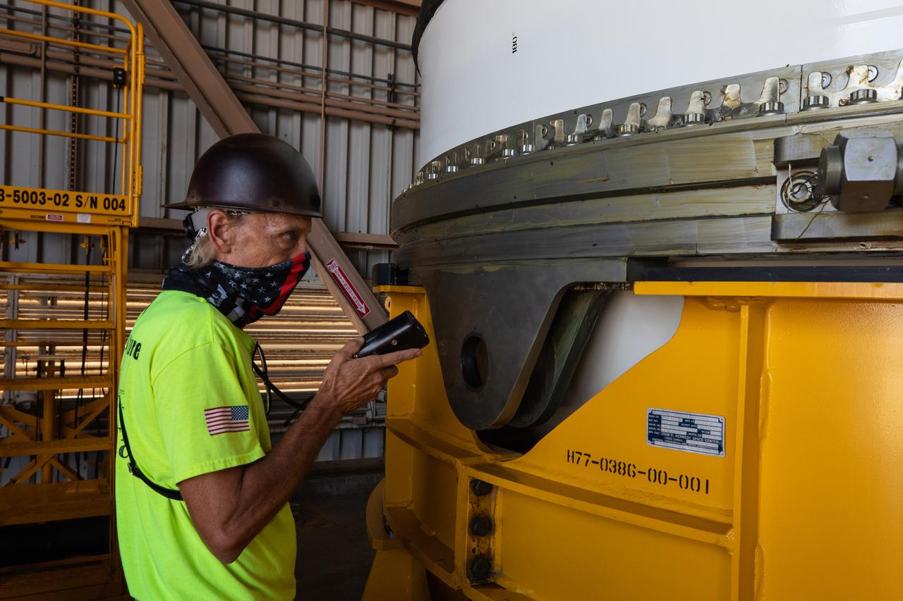 Inside the Rotation, Processing and Surge Facility (RPSF) at NASA’s Kennedy Space Center in Florida, technicians lift the right aft motor segment – one of five segments that make up one of two solid rocket boosters for the agency’s Space Launch System (SLS) – onto an inspection stand on June 23, 2020. While in the RPSF, the boosters will be mated to the rocket’s two aft skirts before they are moved to the Vehicle Assembly Building for stacking on the mobile launcher. The boosters, manufactured by Northrop Grumman in Utah, recently arrived at Kennedy for processing ahead of the Artemis I launch. Together, the twin boosters provide more than 75 percent of the total SLS thrust at launch. The first in a series of increasingly complex missions, Artemis I will test the Orion spacecraft and SLS as an integrated system ahead of crewed flights to the Moon.  