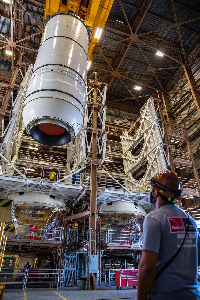 Inside the Rotation, Processing and Surge Facility at NASA’s Kennedy Space Center in Florida, technicians mate the right-hand motor segment – one of five segments that make up one of two solid rocket boosters for the agency’s Space Launch System (SLS) – to the rocket’s right-hand aft skirt on June 24, 2020. Once the aft segments are mated to the two aft skirts, they will be moved to the Vehicle Assembly Building for stacking on the mobile launcher. Manufactured by Northrop Grumman in Utah, the twin boosters provide more than 75 percent of the total SLS thrust at launch. Under the Artemis program, NASA will land the first woman and the next man on the Moon by 2024. The first in a series of increasingly complex missions, Artemis I will test the Orion spacecraft and SLS as an integrated system ahead of crewed flights to the Moon.  
