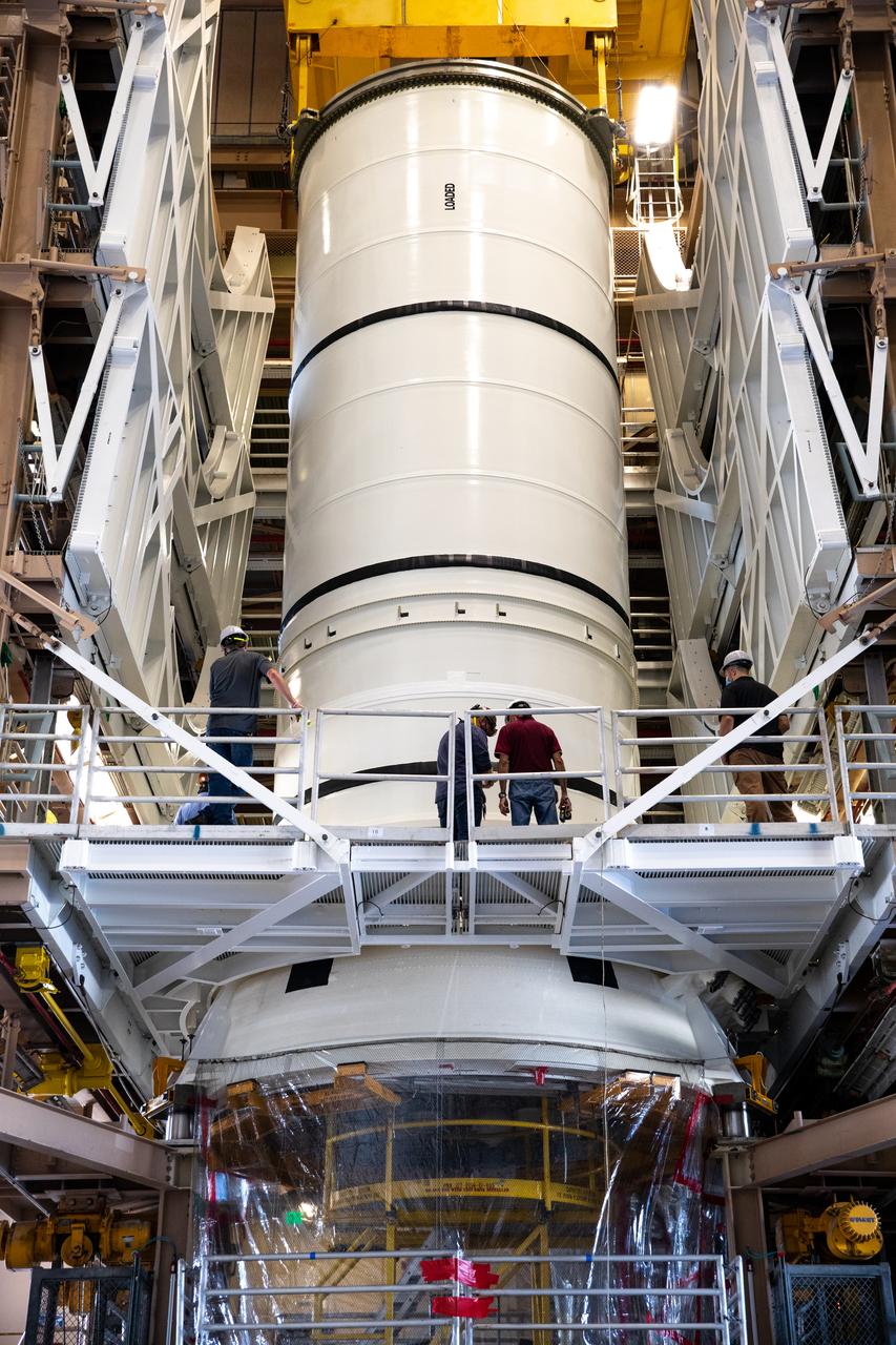 Inside the Rotation, Processing and Surge Facility at NASA’s Kennedy Space Center in Florida, the right-hand motor segment – one of five segments that make up one of two solid rocket boosters for the agency’s Space Launch System (SLS) – is mated to the rocket’s right-hand aft skirt on June 24, 2020. Once the aft segments are mated to the two aft skirts, they will be moved to the Vehicle Assembly Building for stacking on the mobile launcher. Manufactured by Northrop Grumman in Utah, the twin boosters provide more than 75 percent of the total SLS thrust at launch. Under the Artemis program, NASA will land the first woman and the next man on the Moon by 2024. The first in a series of increasingly complex missions, Artemis I will test the Orion spacecraft and SLS as an integrated system ahead of crewed flights to the Moon.