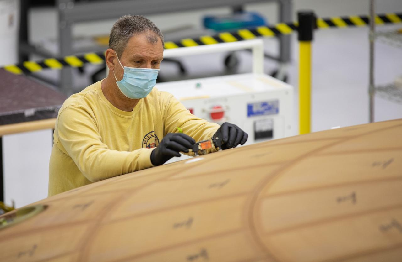 Inside the Neil Armstrong Operations and Checkout Building high bay at NASA's Kennedy Space Center in Florida, technician Kenny Leidner with ASRC Federal, inspects AVCOAT block bonding on the Artemis II heat shield on July 2, 2020. The heat shield is one of the most critical elements of Orion and will protect the capsule and astronauts during reentry through Earth’s atmosphere. Artemis II is the first crewed mission in a series of missions to the Moon and on to Mars. Artemis II will confirm all of the Orion spacecraft’s systems operate as designed in the actual environment of deep space with astronauts aboard. As part of the Artemis Program, NASA will send the first woman and next man to the Moon by 2024.