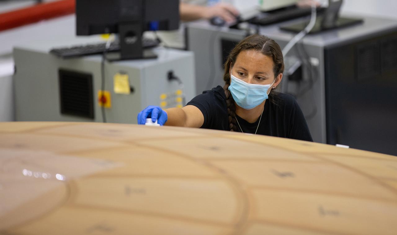 Inside the Neil Armstrong Operations and Checkout Building high bay at NASA's Kennedy Space Center in Florida, technician Diamond ScharSenstine with ASRC Federal, inspects AVCOAT block bonding on the Artemis II heat shield on July 2, 2020. The heat shield is one of the most critical elements of Orion and will protect the capsule and astronauts during reentry through Earth’s atmosphere. Artemis II is the first crewed mission in a series of missions to the Moon and on to Mars. Artemis II will confirm all of the Orion spacecraft’s systems operate as designed in the actual environment of deep space with astronauts aboard. As part of the Artemis Program, NASA will send the first woman and next man to the Moon by 2024.