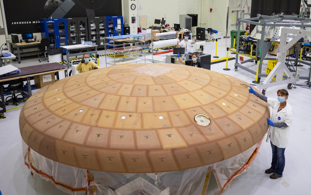 Inside the Neil Armstrong Operations and Checkout Building high bay at NASA's Kennedy Space Center in Florida, from left, technicians Kenny Leidner, Diamond ScharSenstine, Russ Novak and Darlene Beville with ASRC Federal, inspect AVCOAT block bonding on the Artemis II heat shield on July 2, 2020. The heat shield is one of the most critical elements of Orion and will protect the capsule and astronauts during reentry through Earth’s atmosphere. Artemis II is the first crewed mission in a series of missions to the Moon and on to Mars. Artemis II will confirm all of the Orion spacecraft’s systems operate as designed in the actual environment of deep space with astronauts aboard. As part of the Artemis Program, NASA will send the first woman and next man to the Moon by 2024.